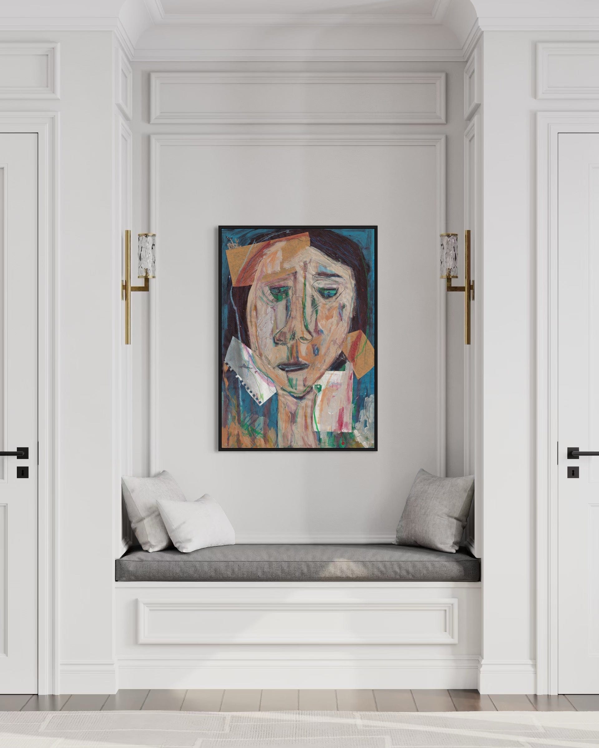Artistic portrait on a wall above a cushioned bench in a stylish interior.