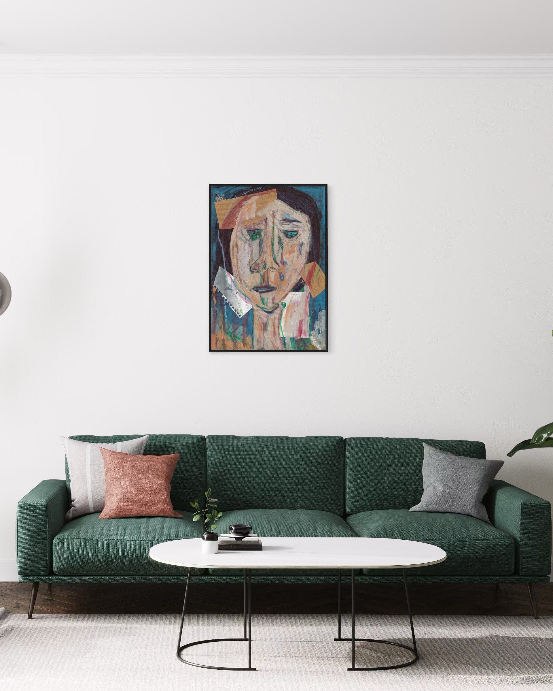 Green sofa with decorative pillows in a living room setting, featuring a painting on the wall.