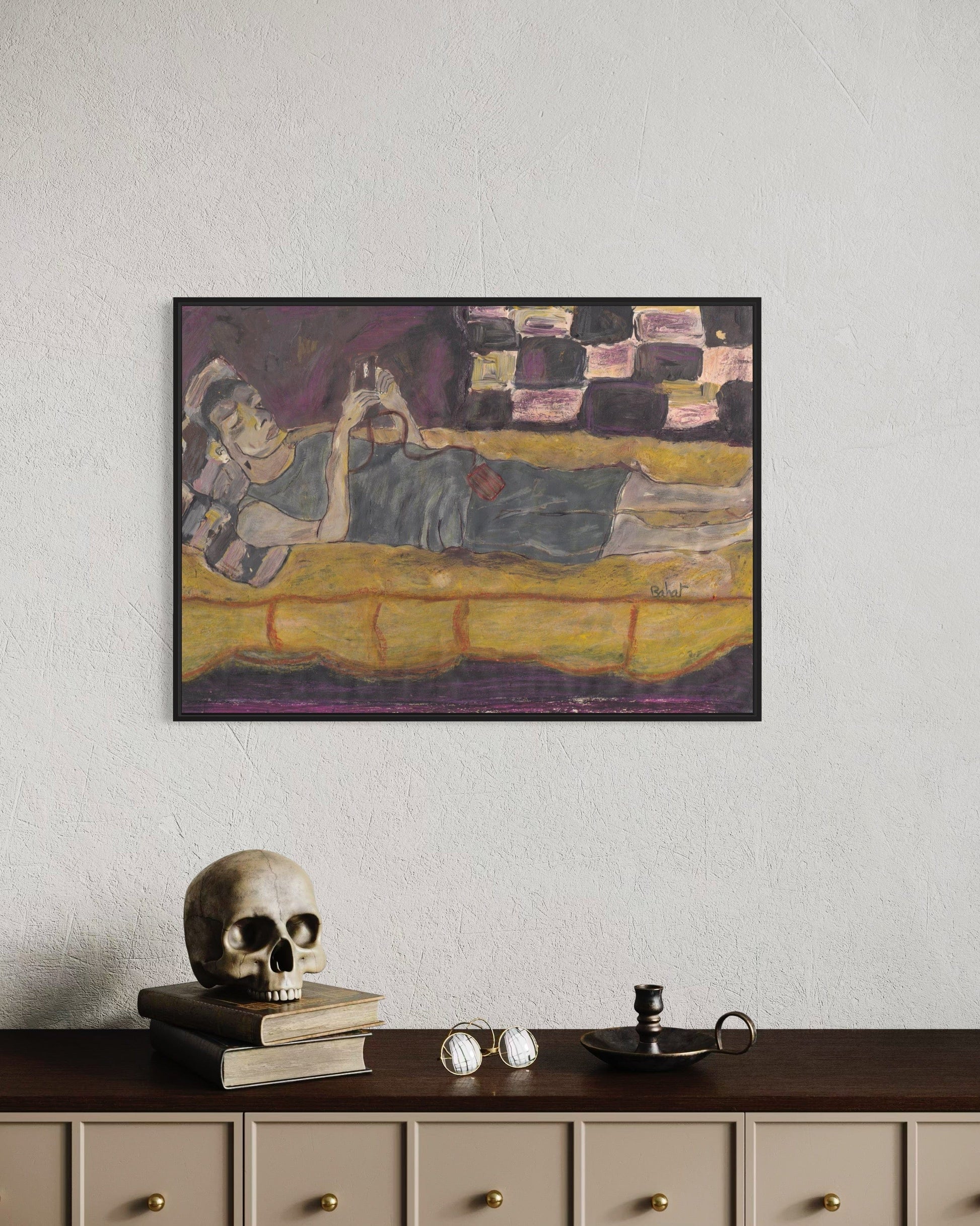 Framed painting on a wall above a wooden cabinet with decorative items.