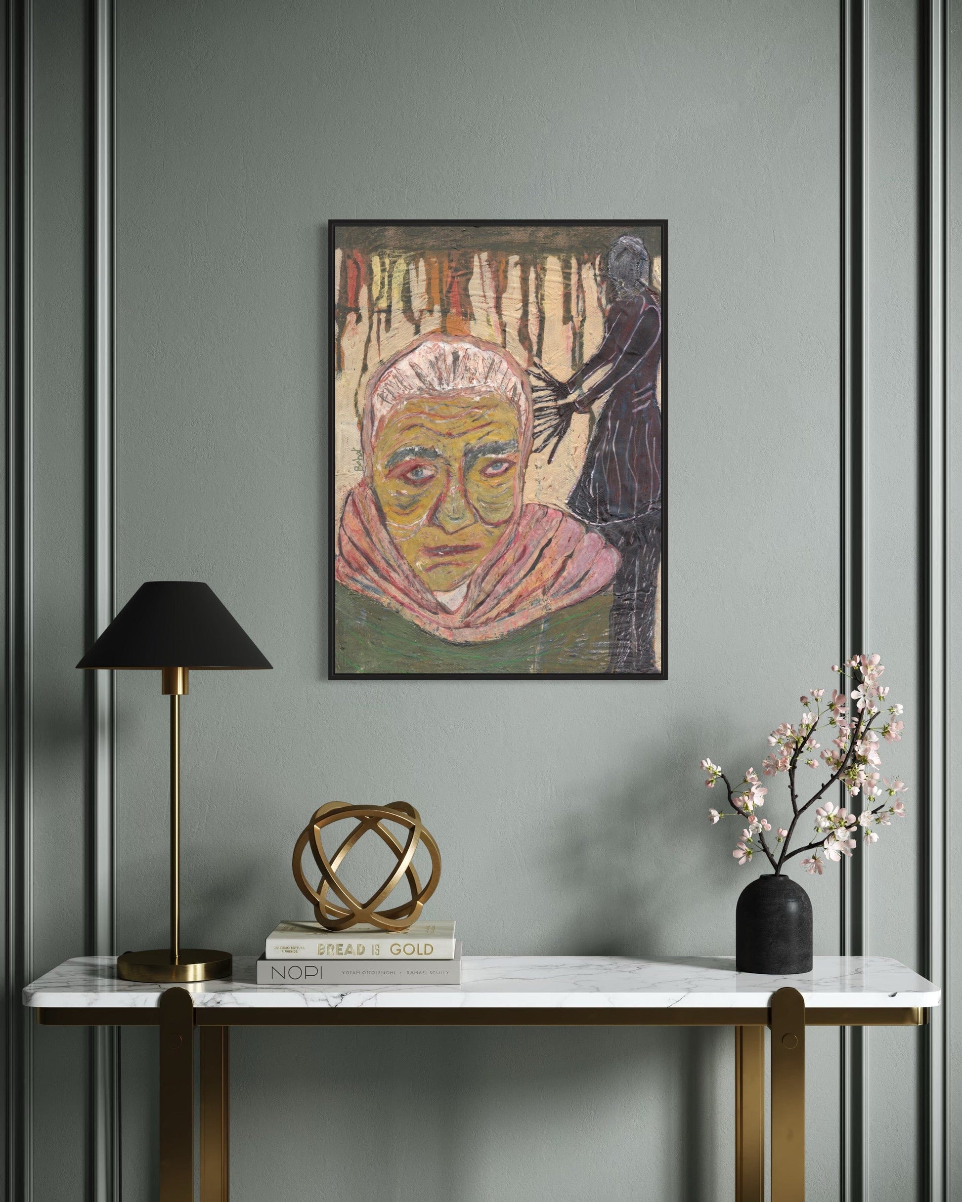 Framed artwork on a wall above a console table with decorative items.