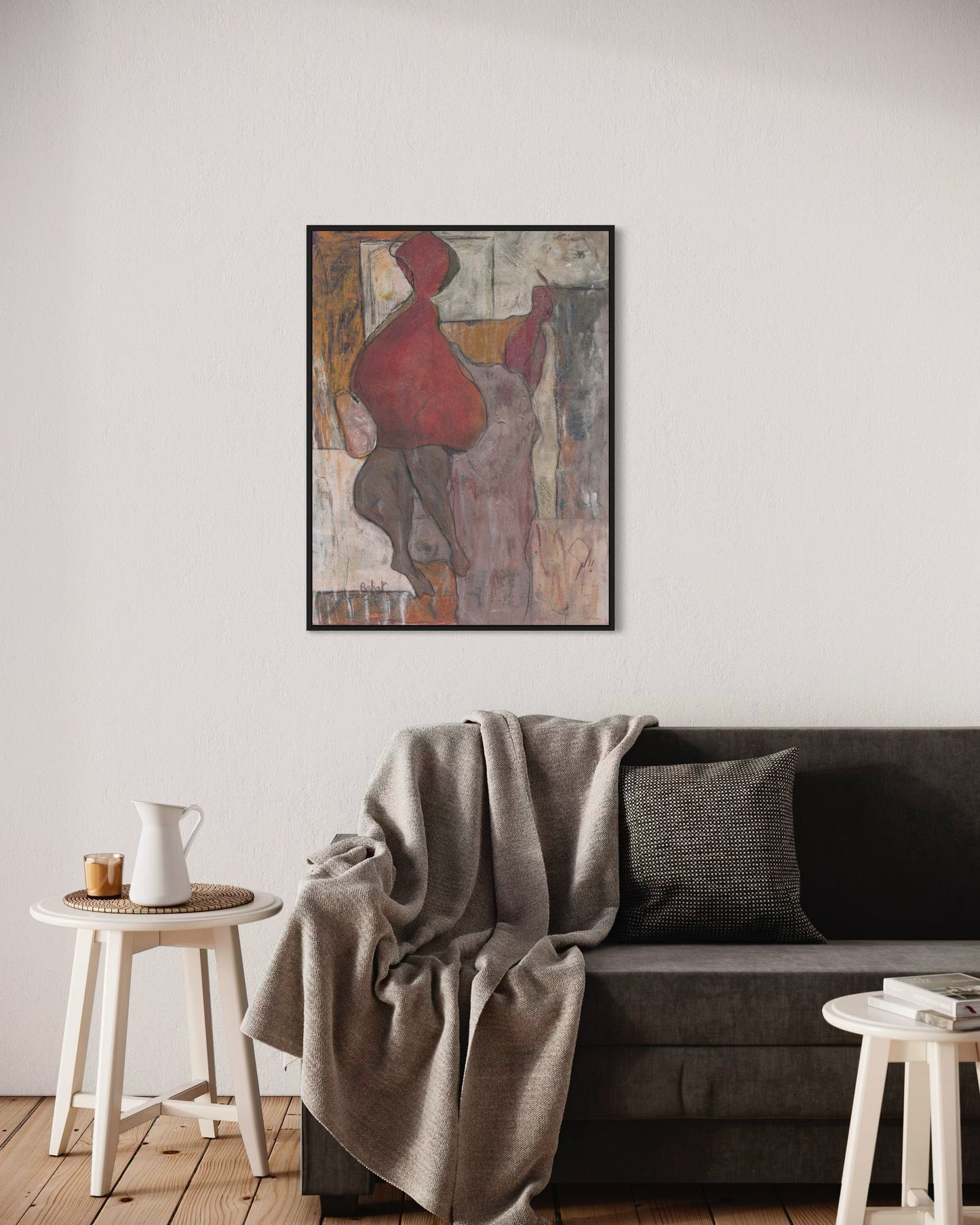 Living room with a gray sofa, abstract painting on the wall, and small side tables.
