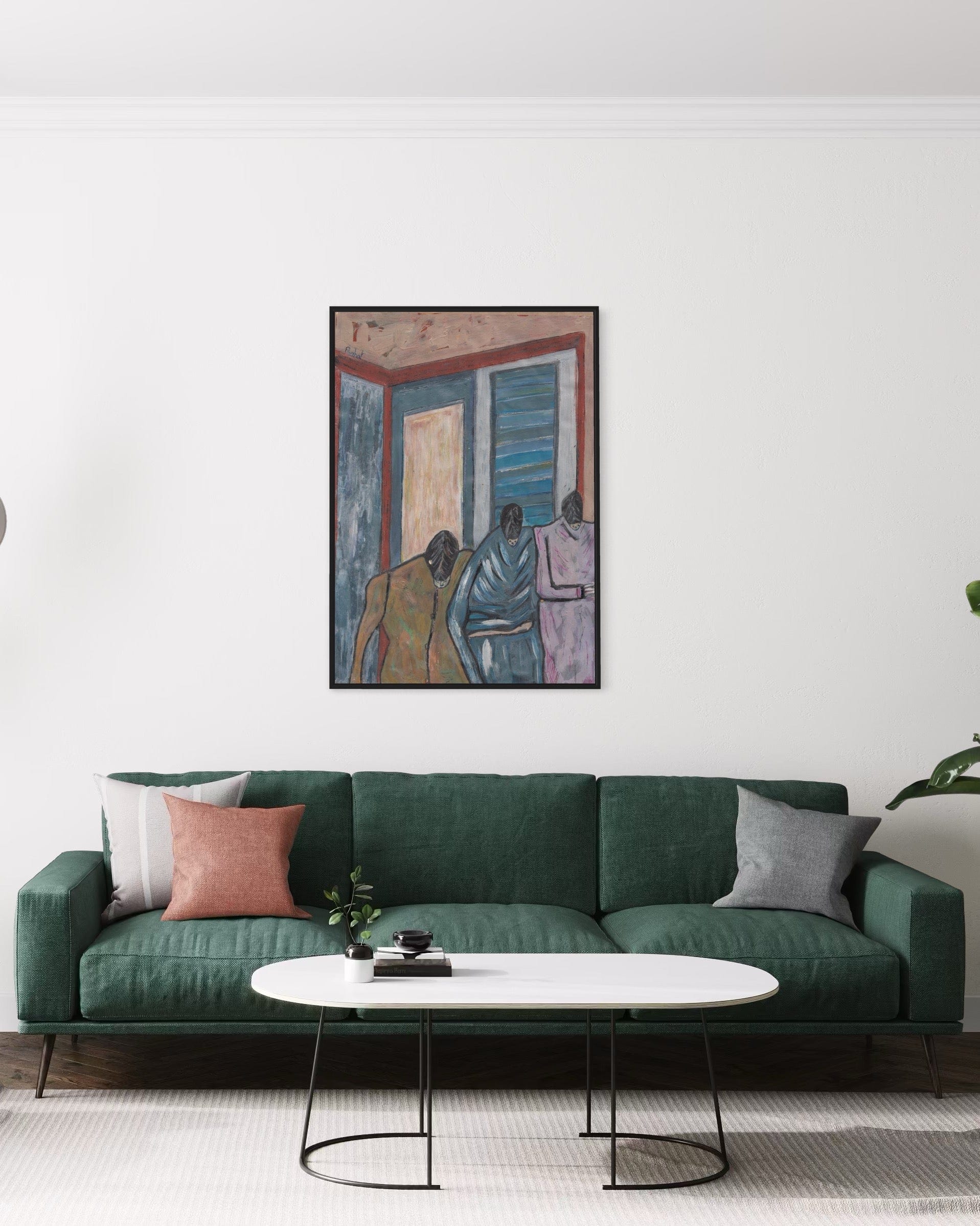 Green sofa with decorative pillows in a living room setting, featuring a framed artwork on the wall.