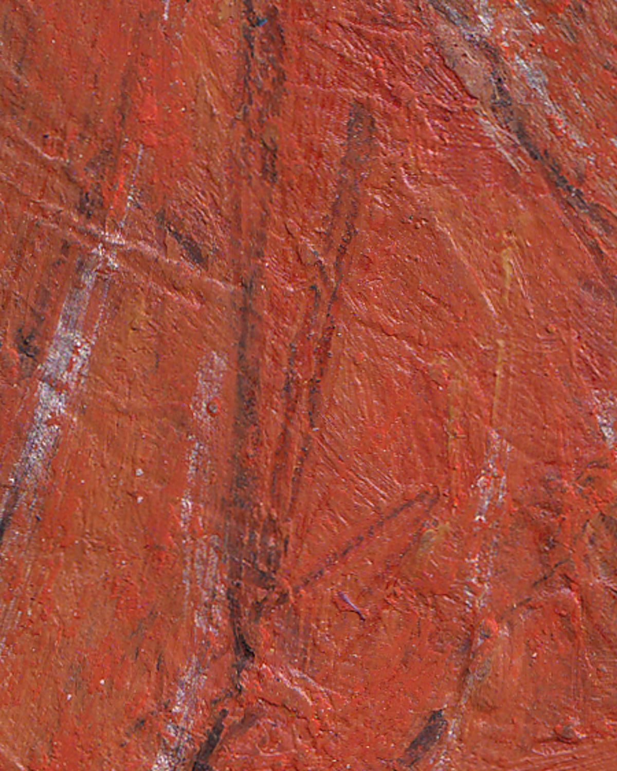 Close-up of a textured red surface with brown streaks