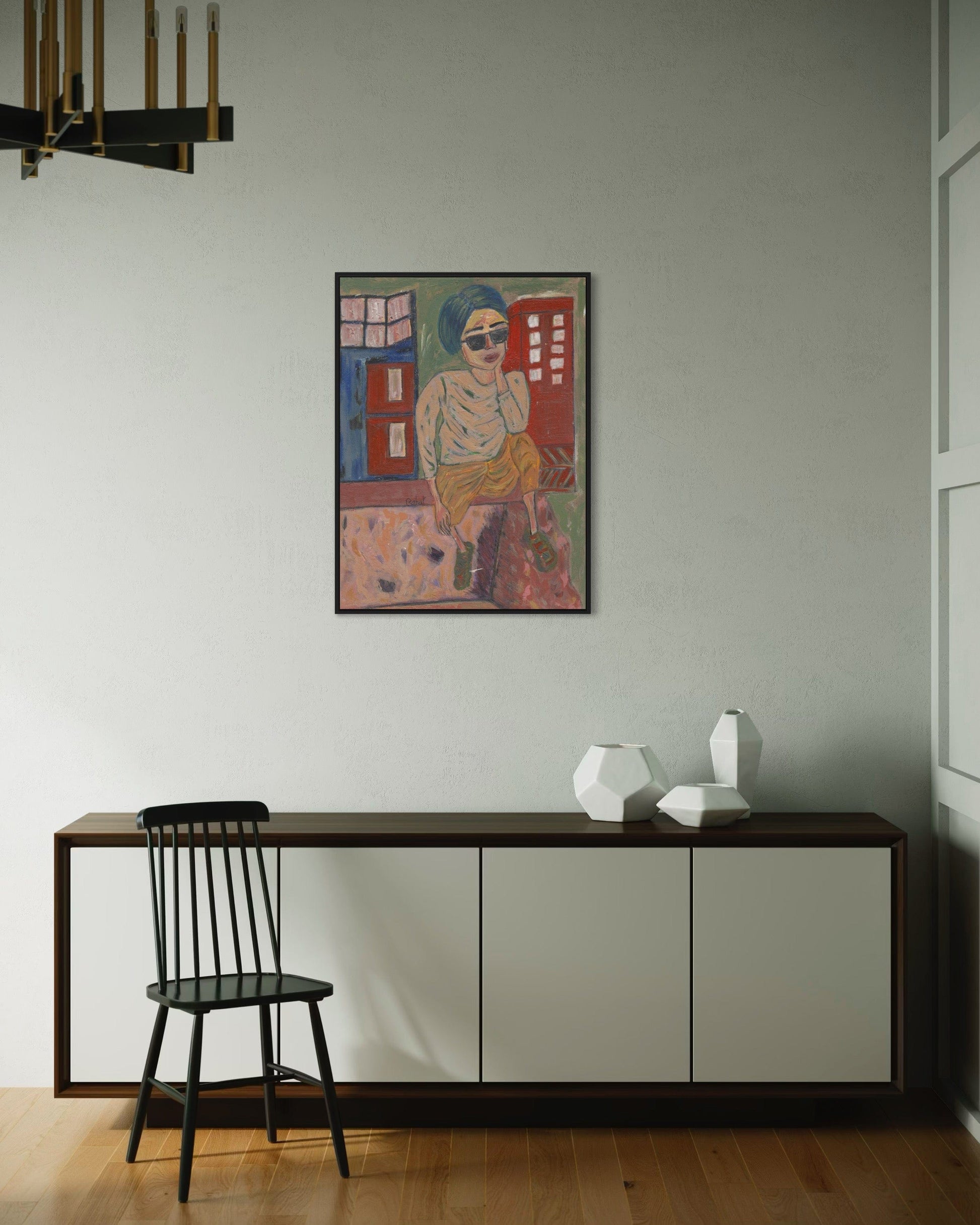 Modern interior with a colorful painting on the wall, a black chair, and a wooden sideboard.