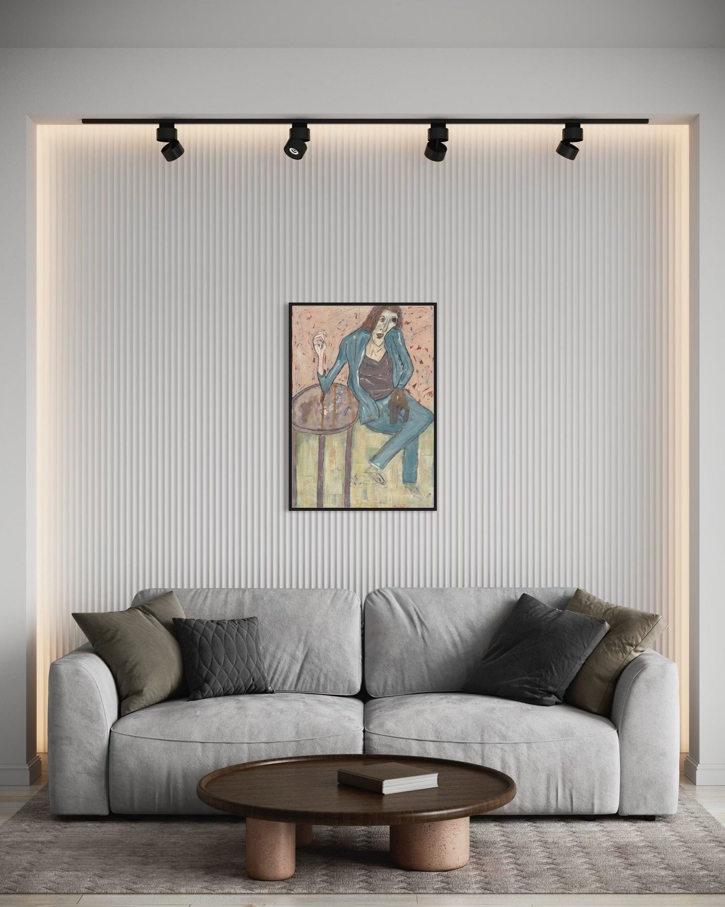 Gray sofa in a living room with a wall painting and round wooden coffee table.