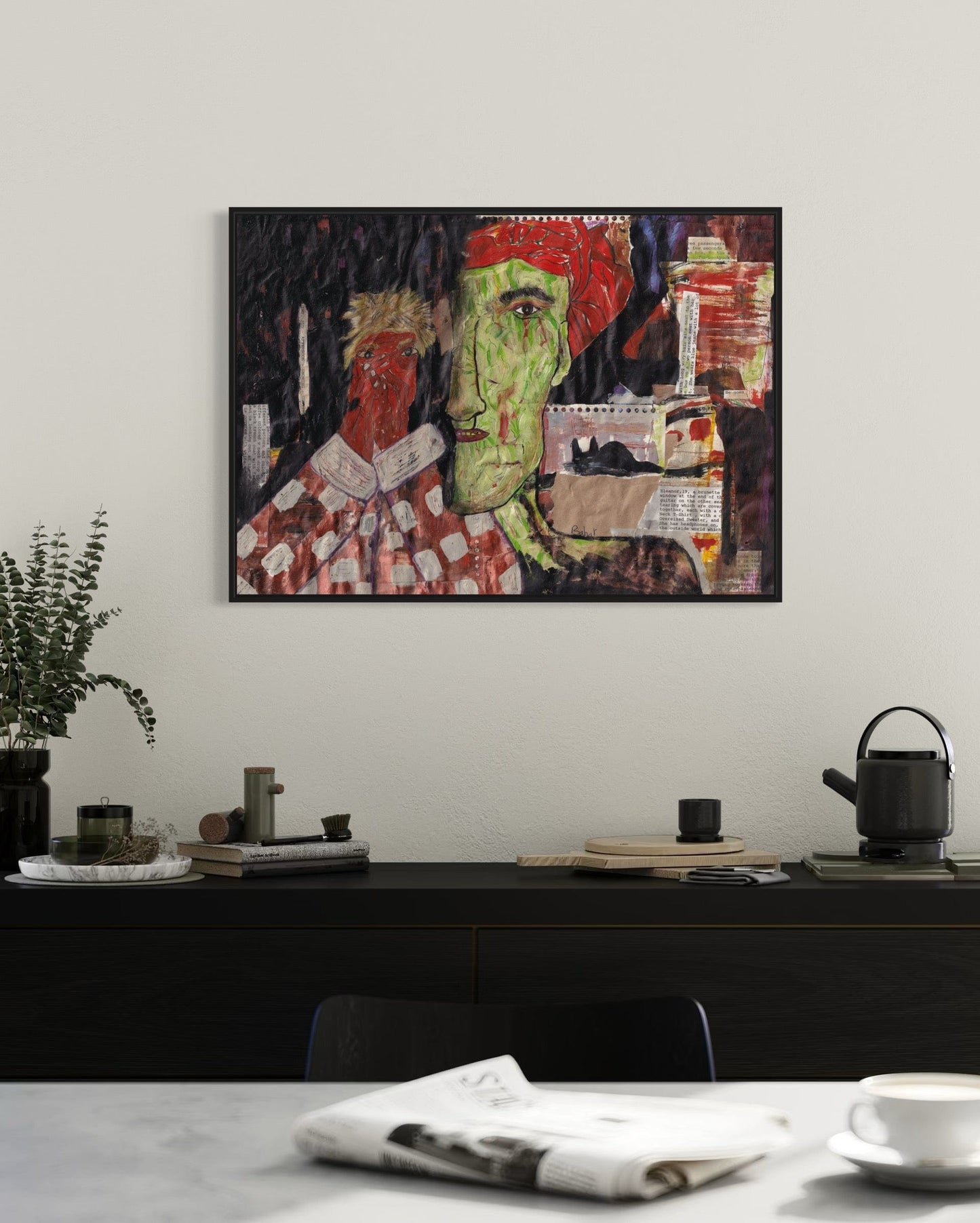 Framed abstract artwork on a wall above a table with decor items.