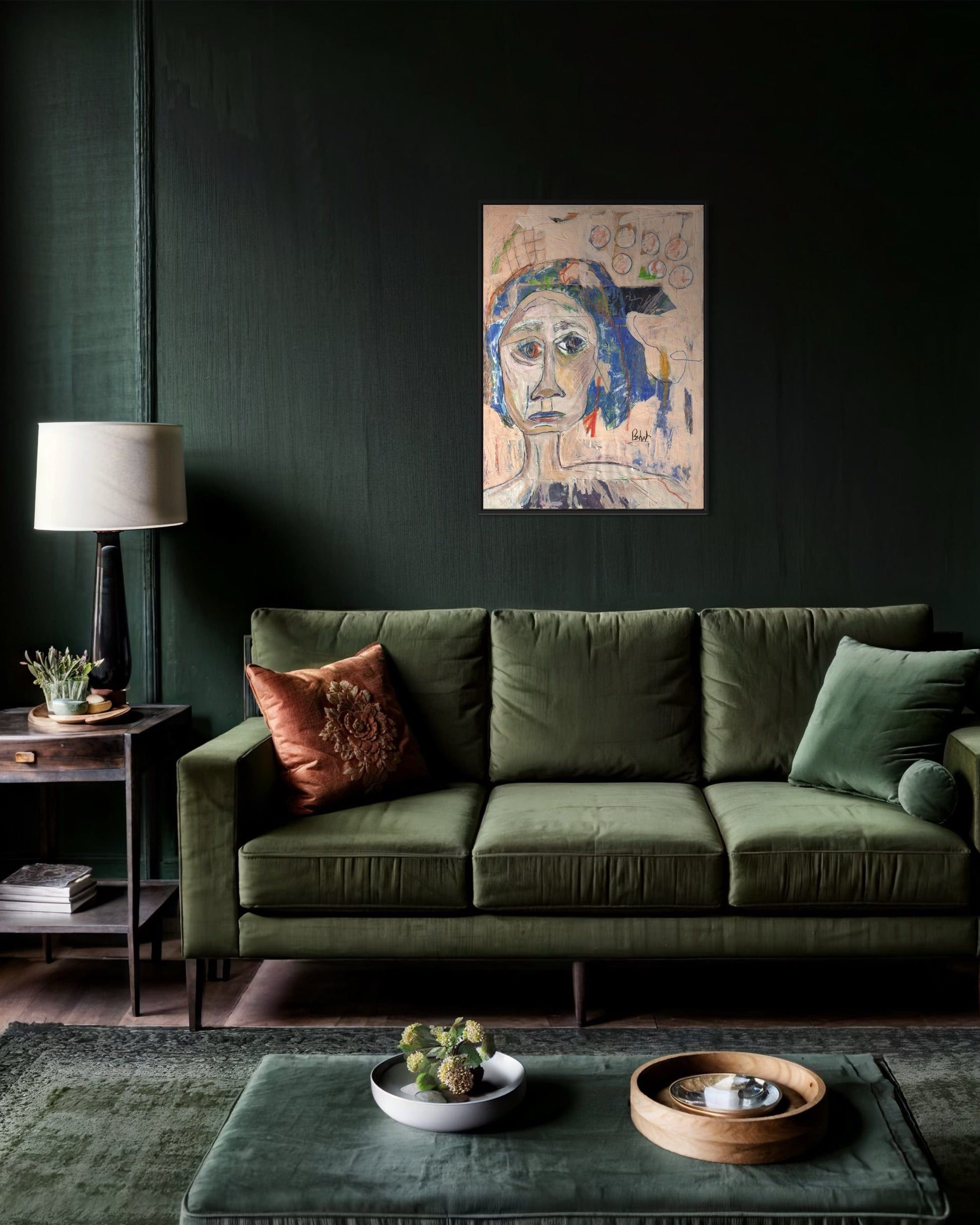 Green sofa in a living room with a dark wall, lamp, and decorative items.