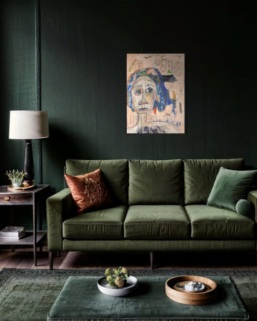 Green sofa in a living room with a dark wall, lamp, and decorative items.