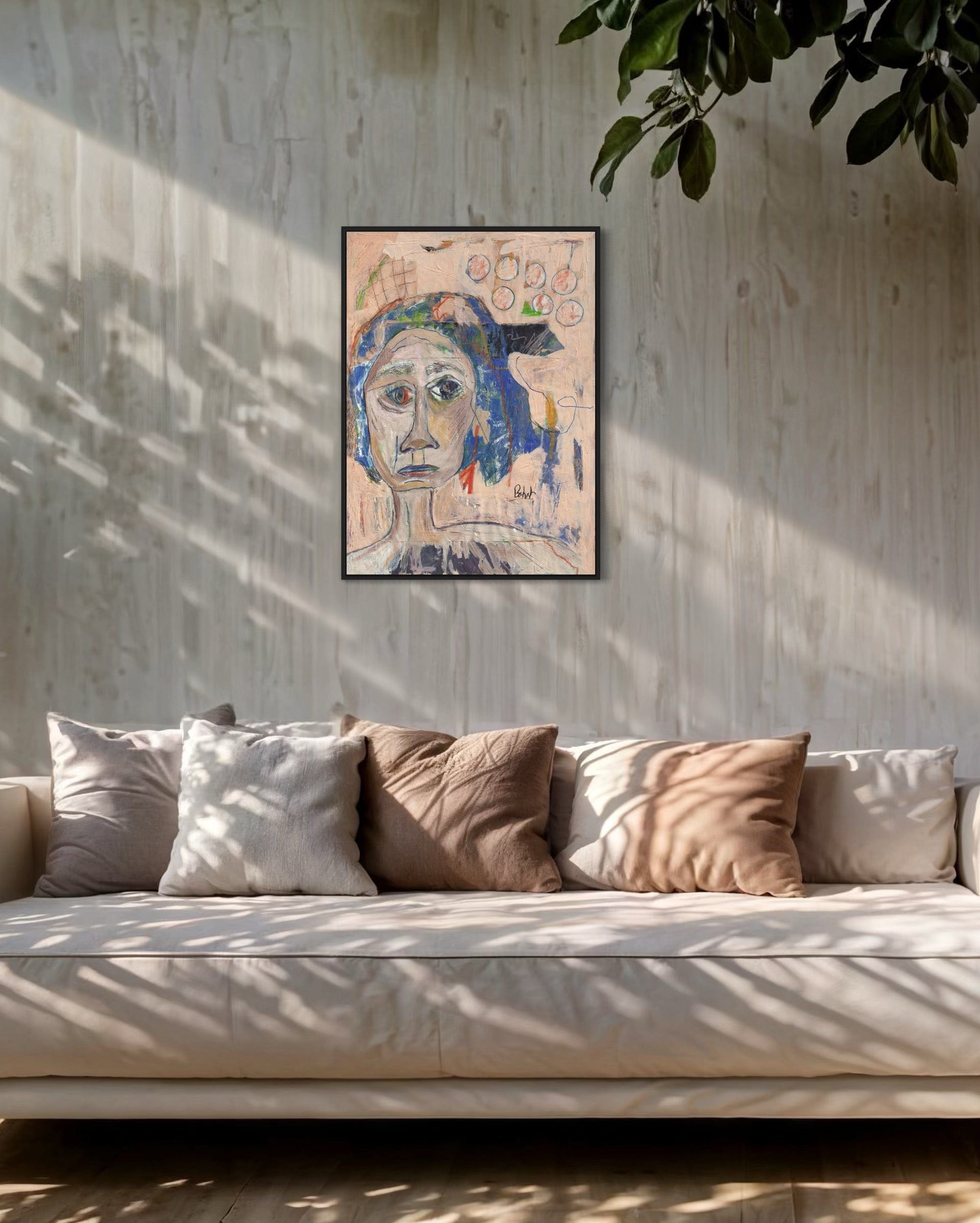 Framed abstract artwork on a wall above a sofa with cushions.