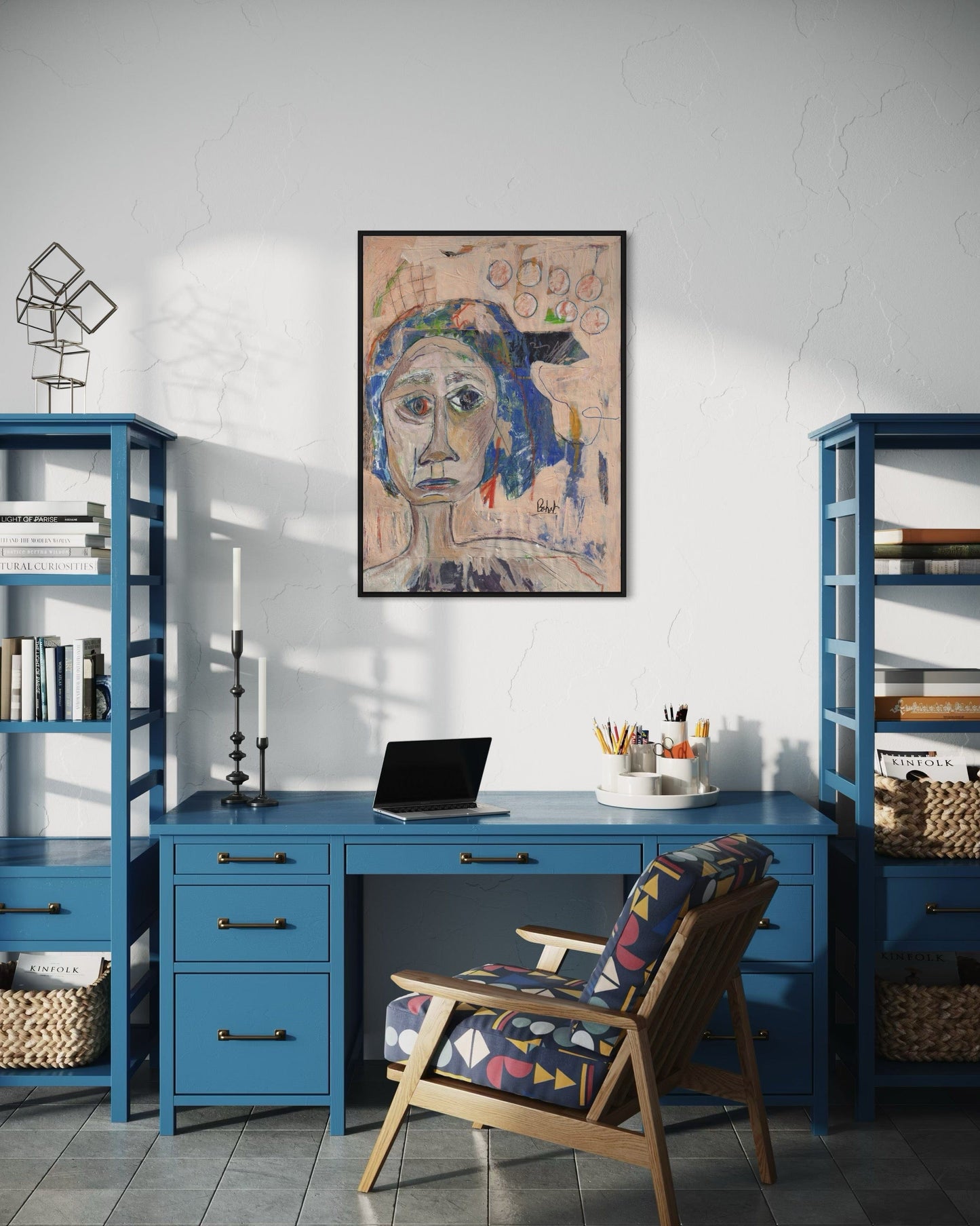 Home office with blue desk, chair, and bookshelves, featuring a framed artwork on the wall.