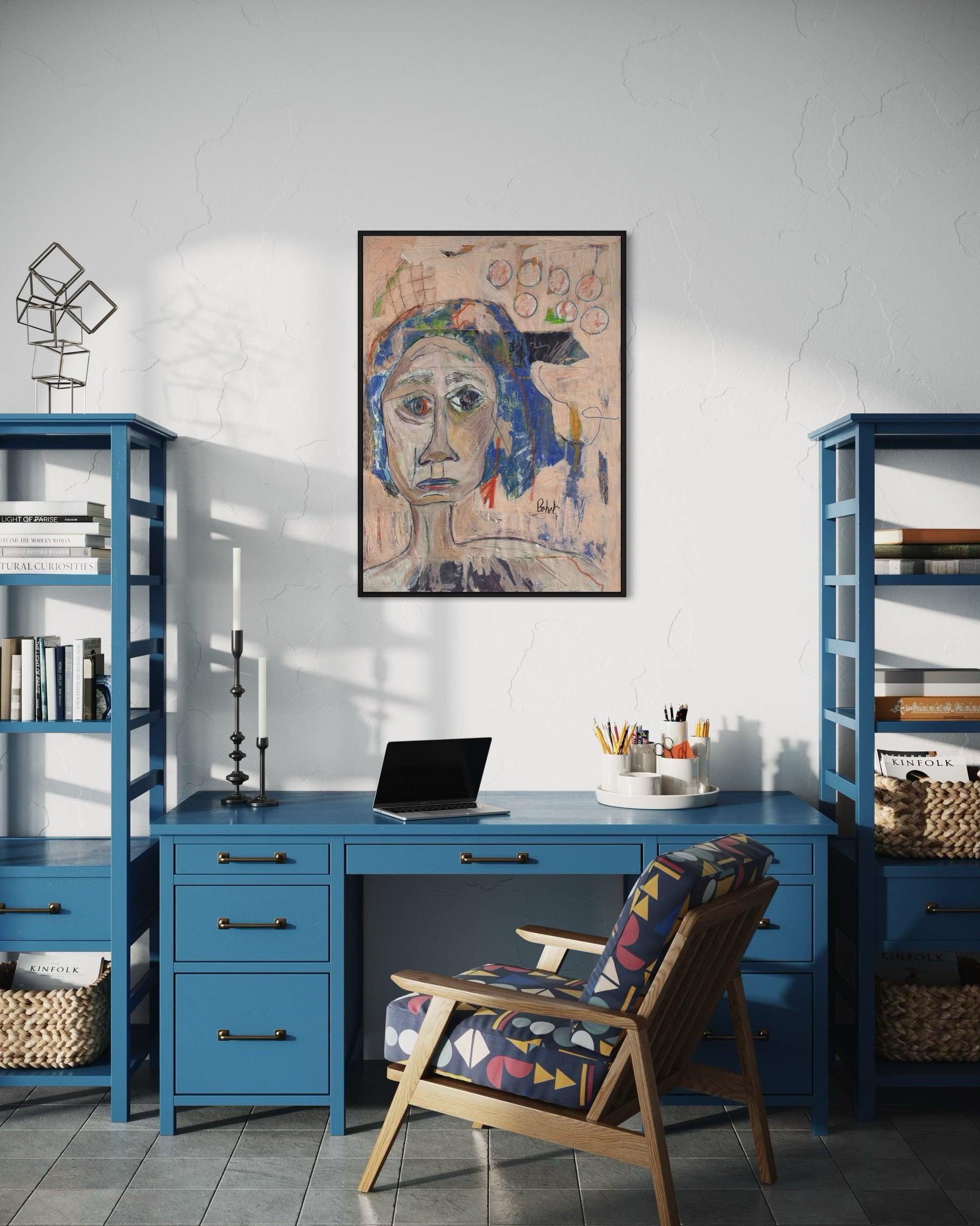 Home office with blue desk, chair, and bookshelves, featuring a framed artwork on the wall.