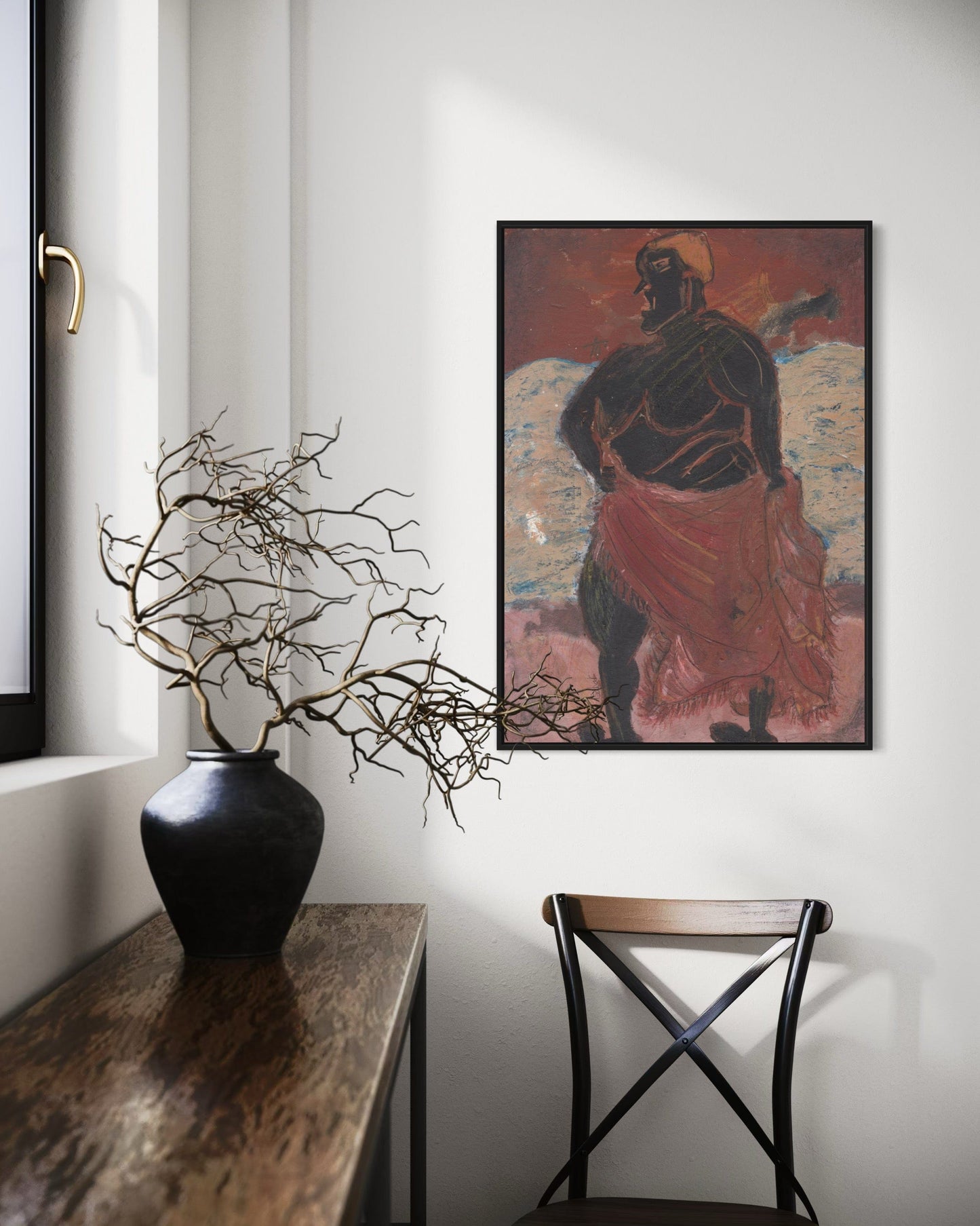 Decorative setup with a vase, branches, and a framed painting on a wall.