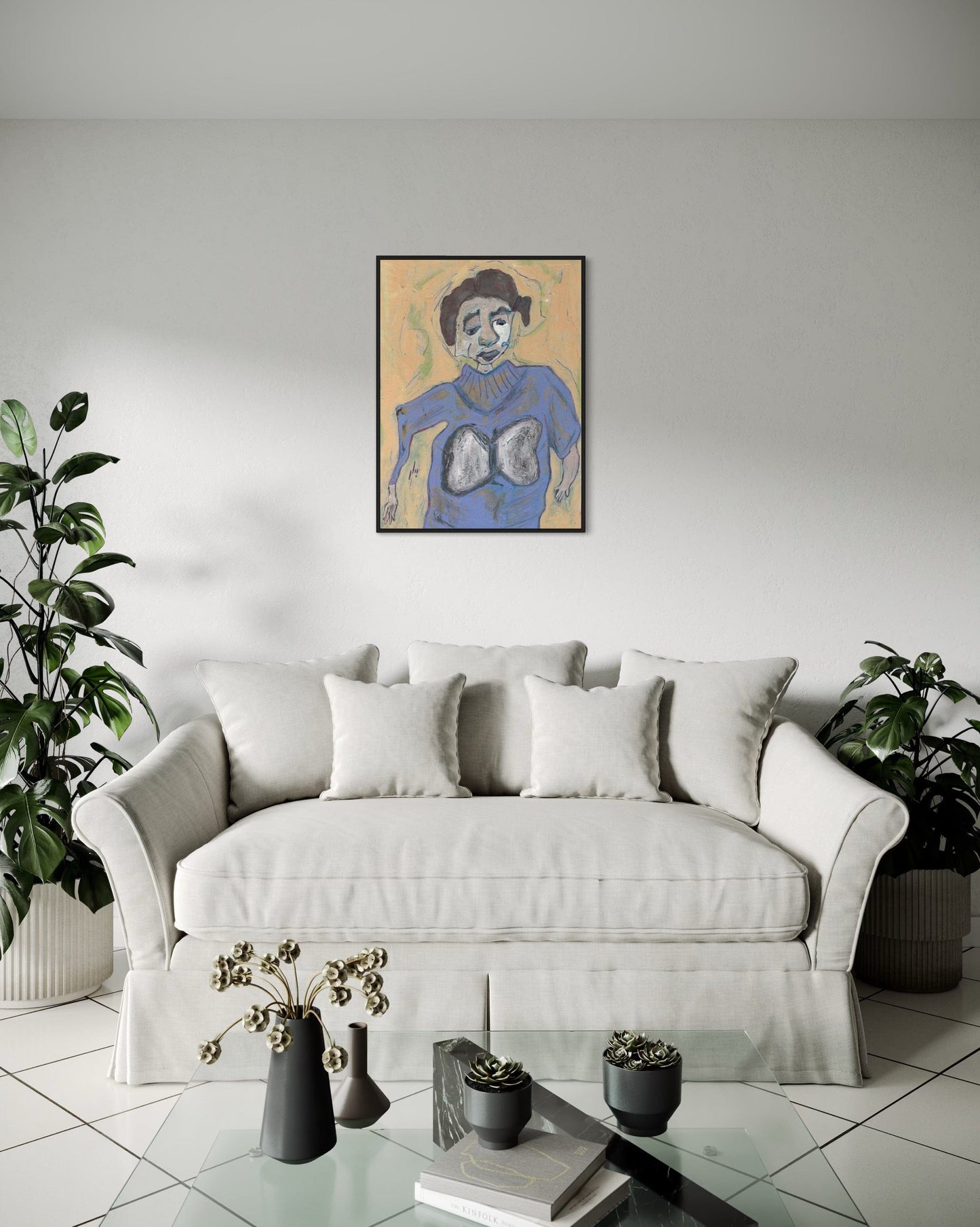 Living room with a white sofa, decorative pillows, and a framed artwork on the wall.