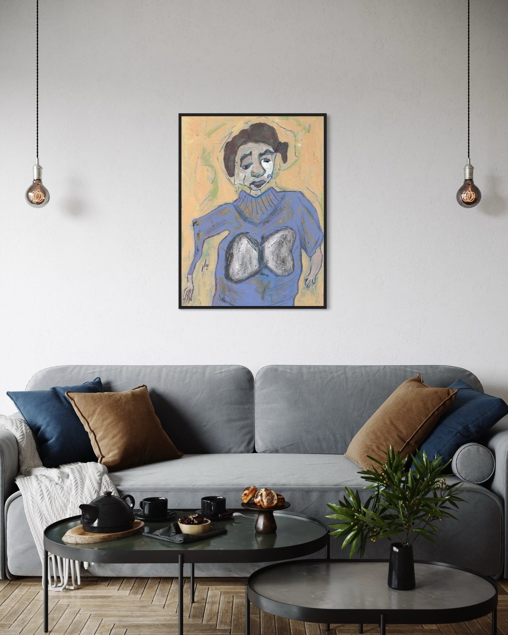 Living room with a gray sofa, coffee table, and wall art of a person with lungs.