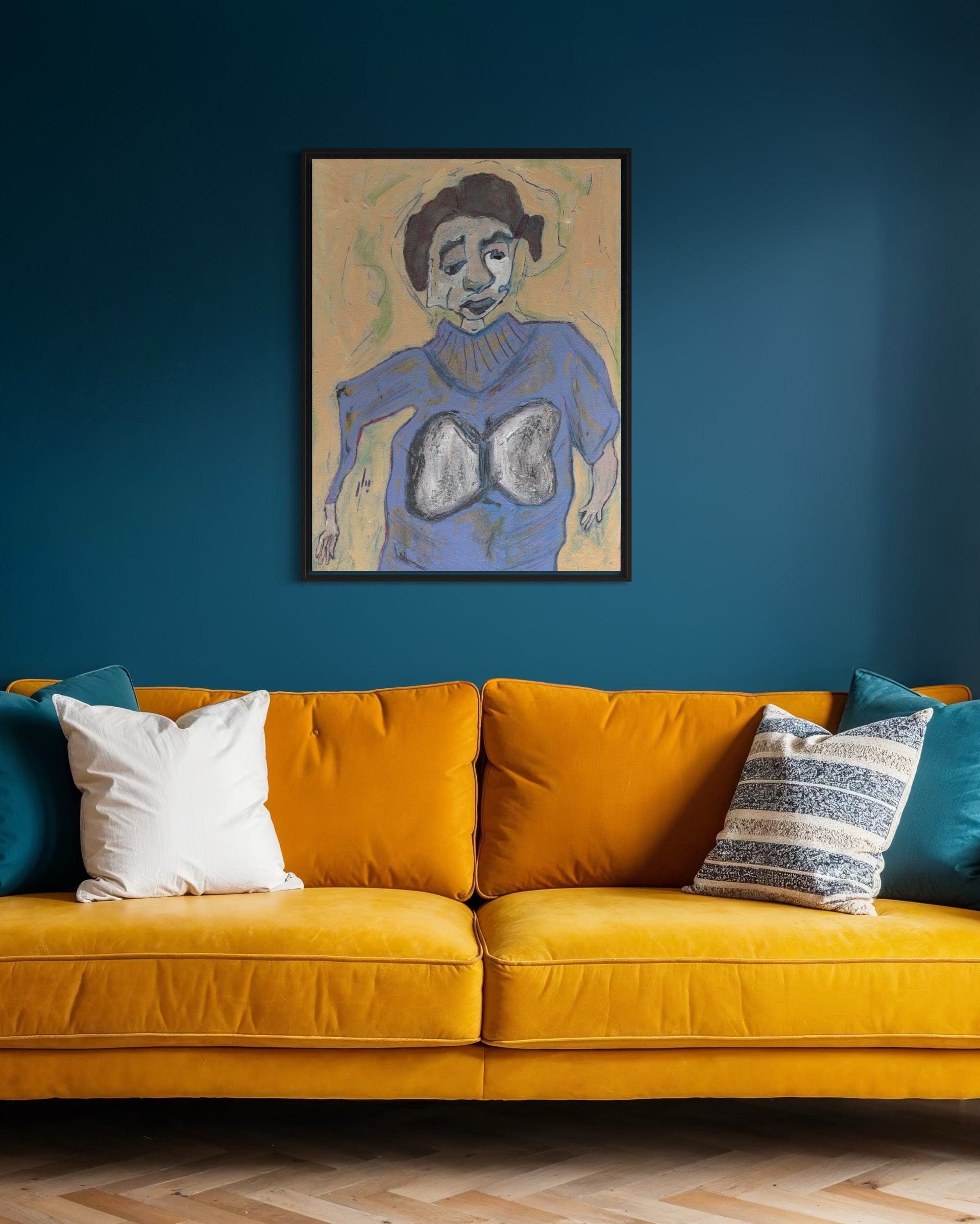 Yellow sofa with colorful cushions against a blue wall with a framed artwork.
