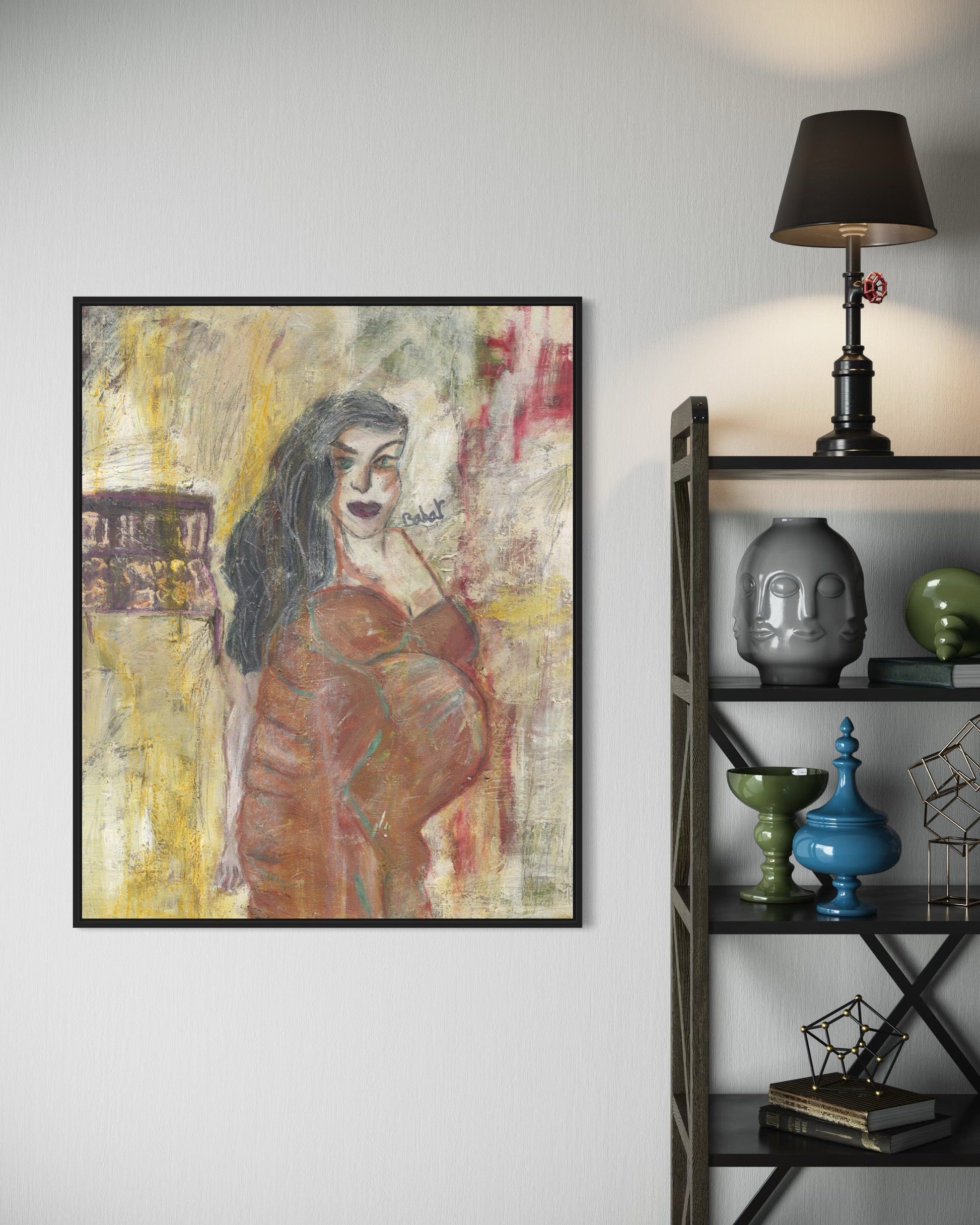 Framed abstract artwork of a woman on a wall next to a bookshelf with decorative items.