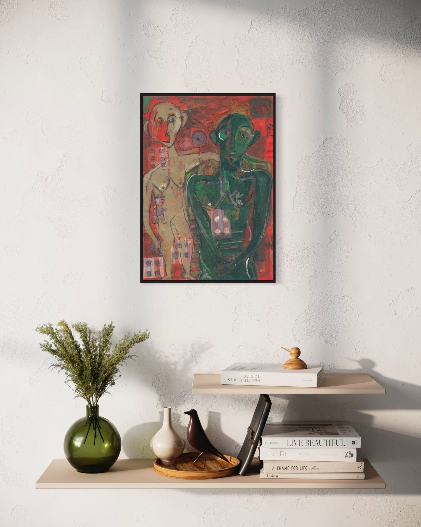 Framed abstract artwork on a wall above a shelf with decorative items.