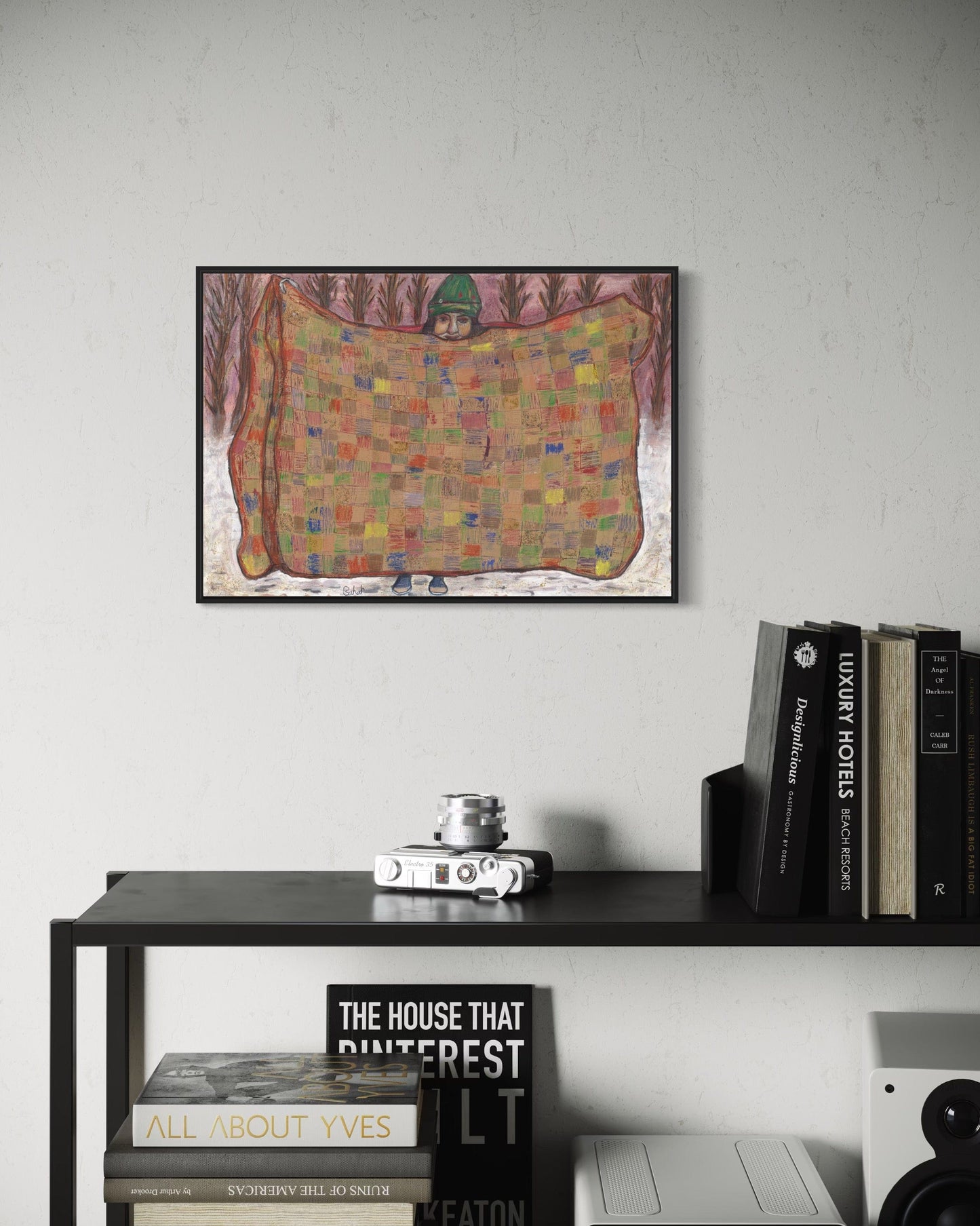 Framed abstract artwork on a wall above a shelf with books and decor items.