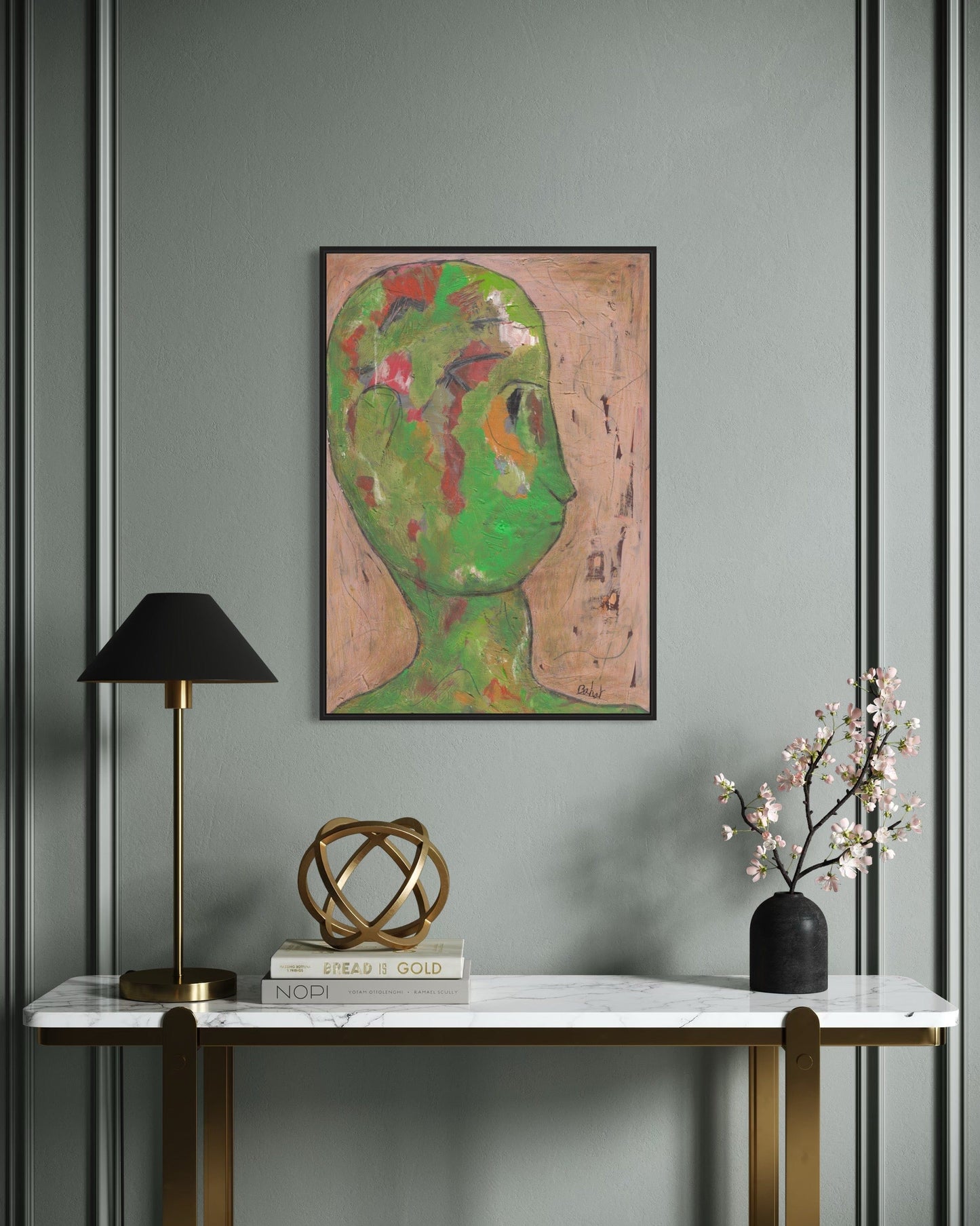 Decorative interior setting with a painting of a stylized face, lamp, sculpture, and vase on a marble surface.