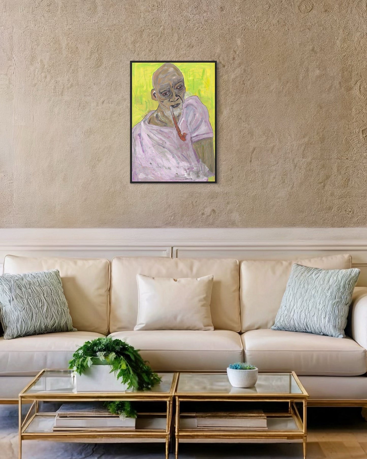 Framed artwork of a person on a wall above a beige sofa with decorative items.