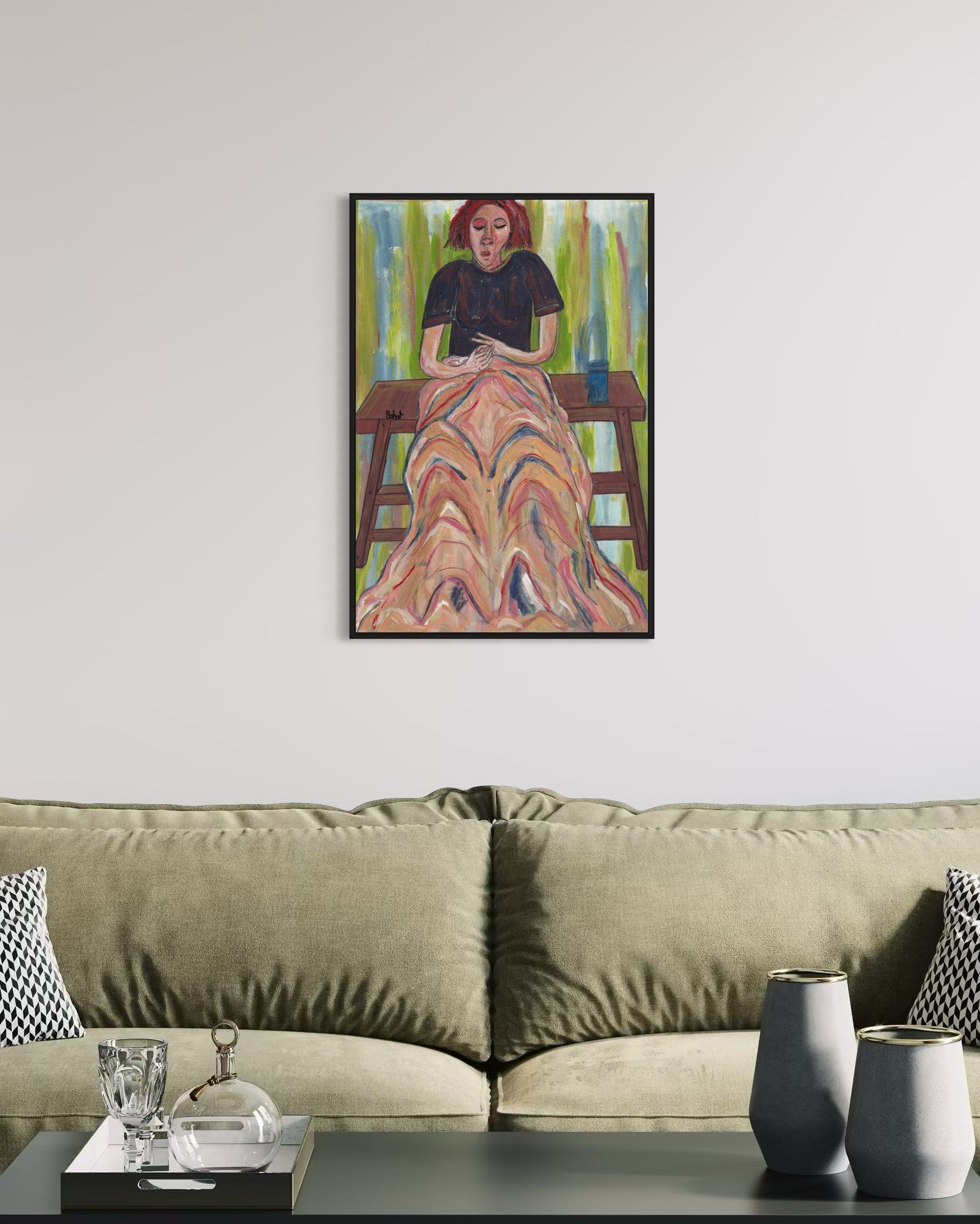 Framed artwork of a woman on a wall above a sofa in a living room.