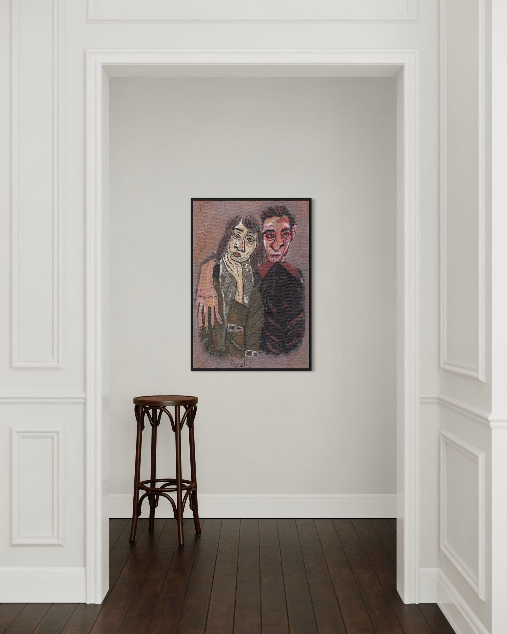 Framed artwork on a wall with a wooden stool in front