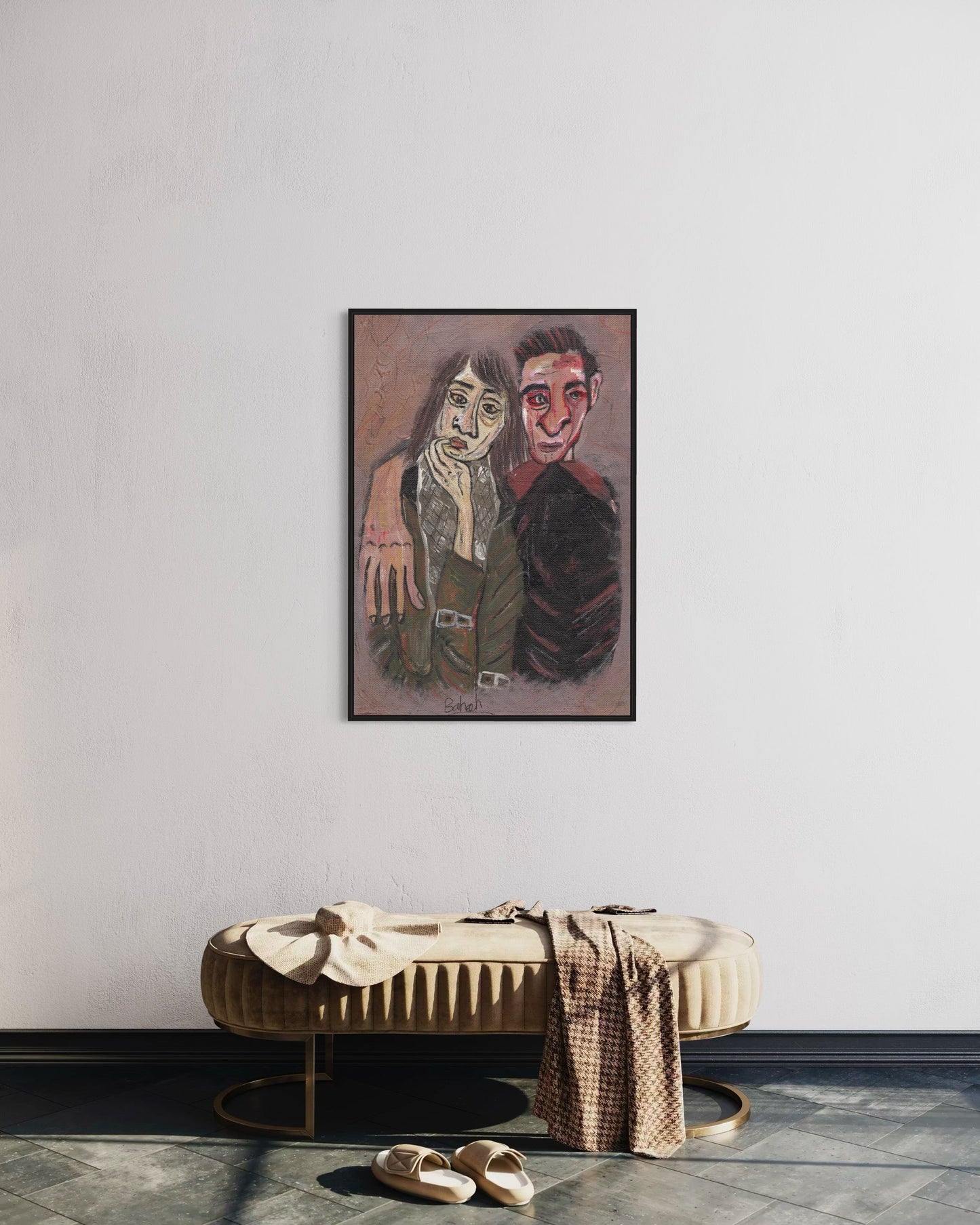 Framed artwork of two people on a wall above a bench with shoes and a bag.
