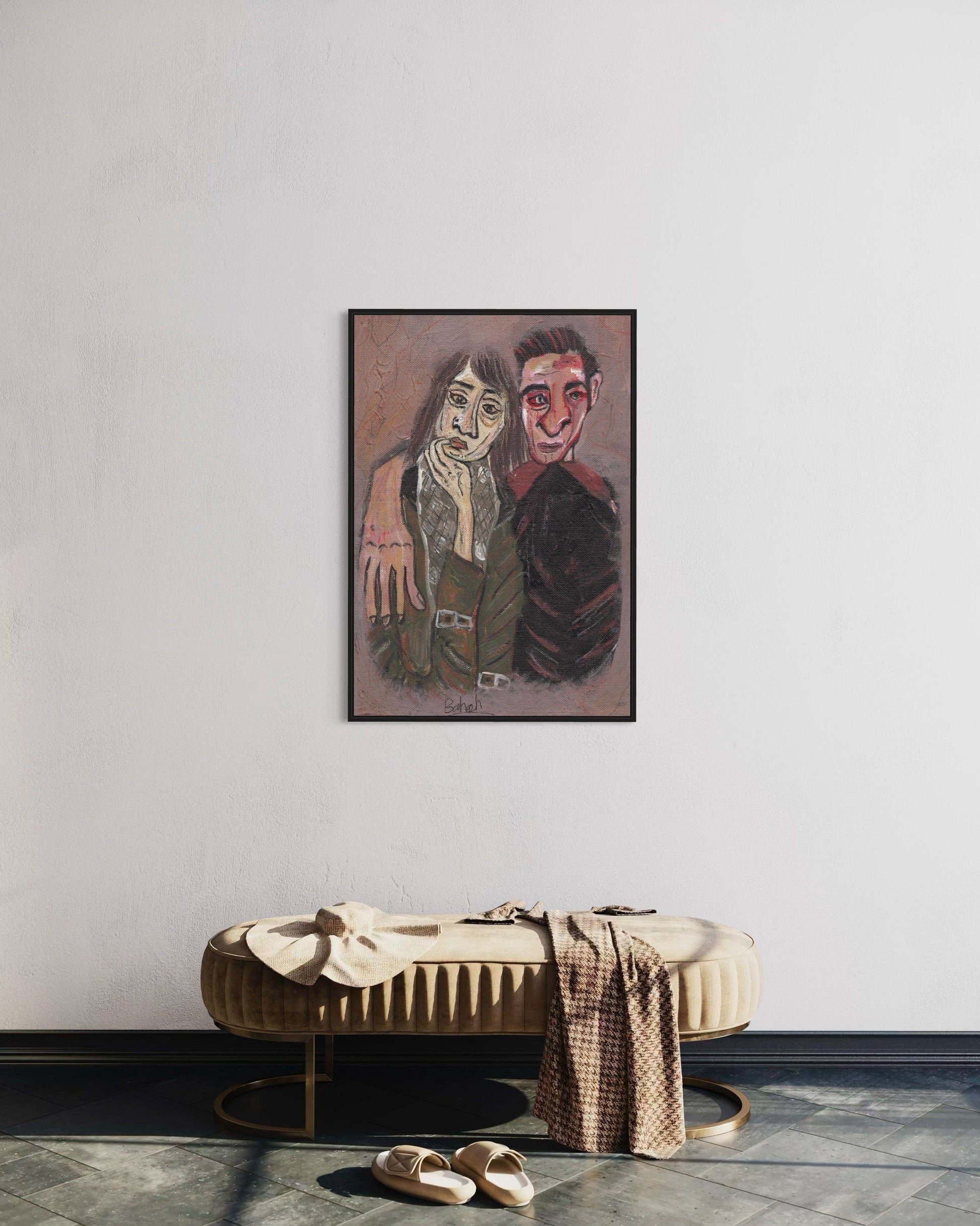Framed artwork of two people on a wall above a bench with shoes and a bag.