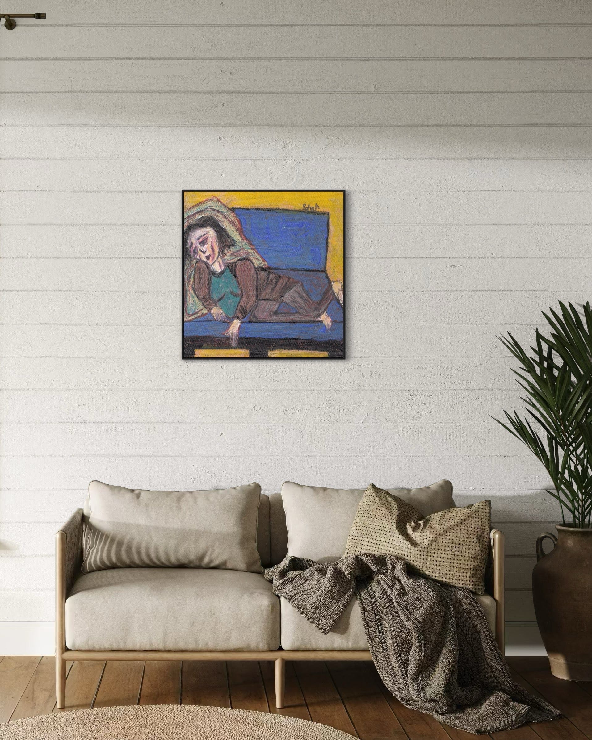Living room with a beige sofa, plant, and abstract painting on a white wall.