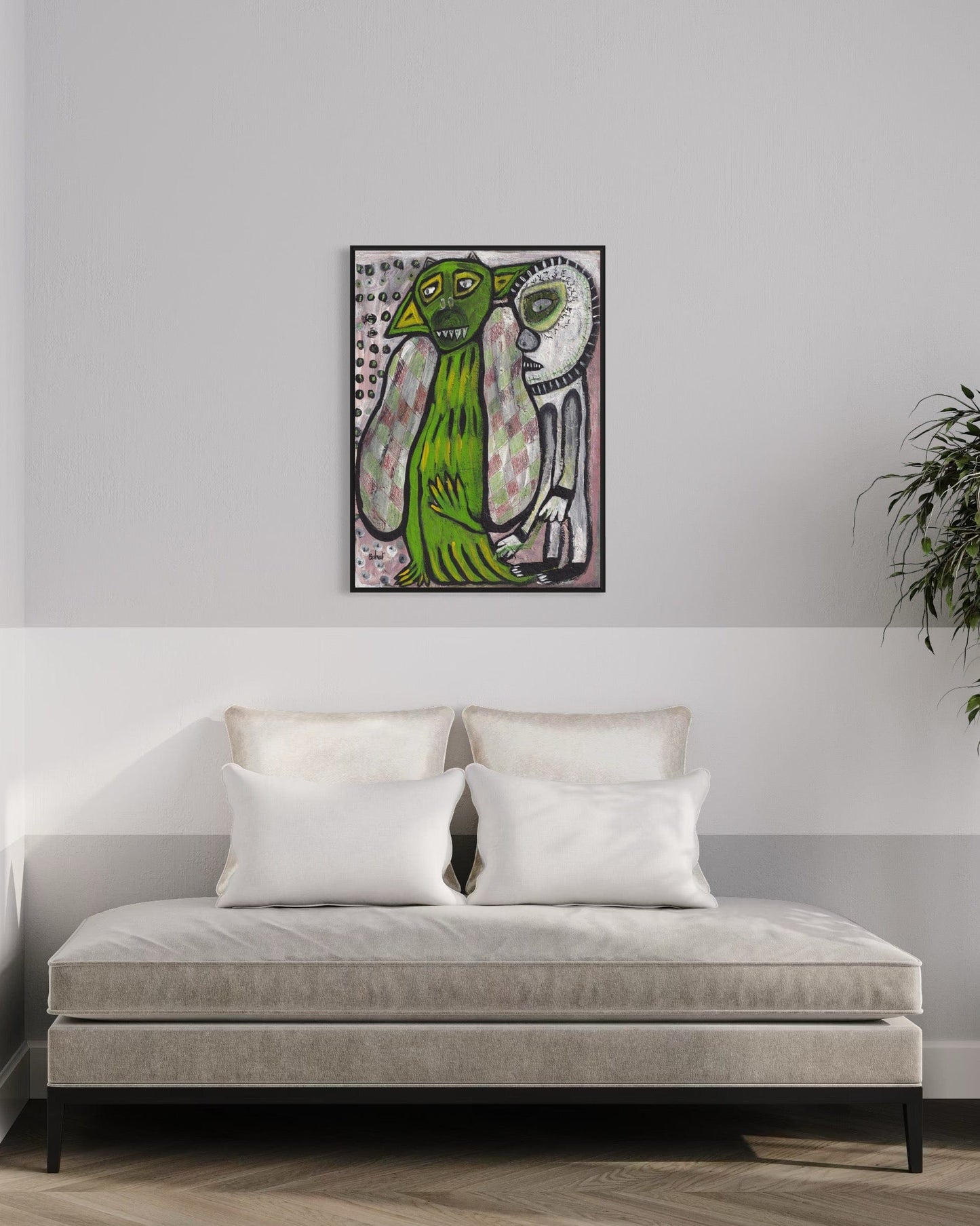 Framed artwork of two green creatures on a wall above a sofa.