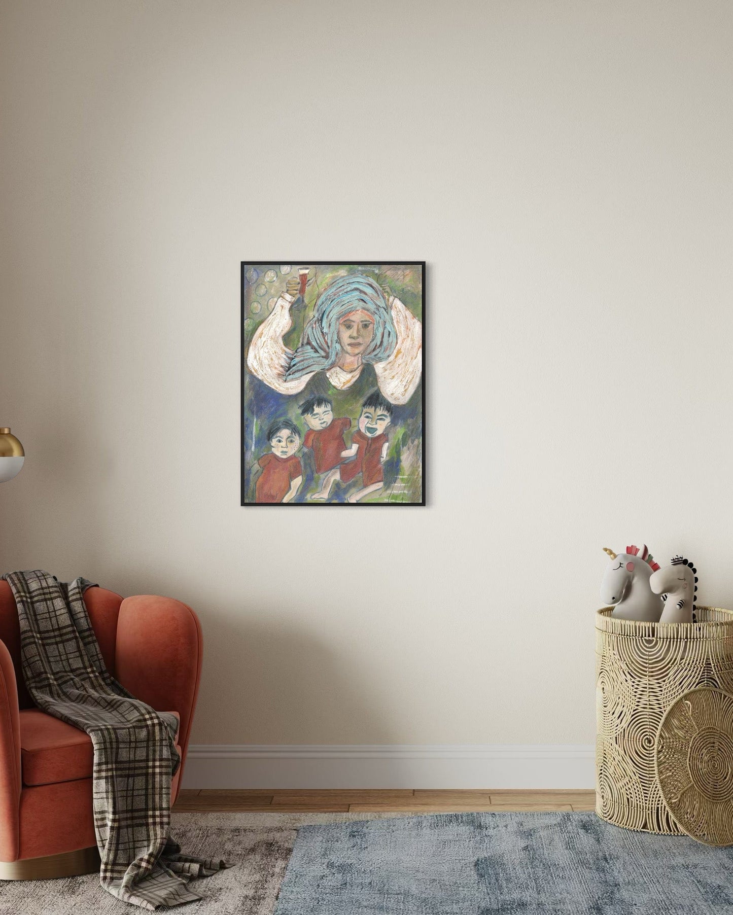 Framed artwork on a wall above a red armchair with a plaid blanket.