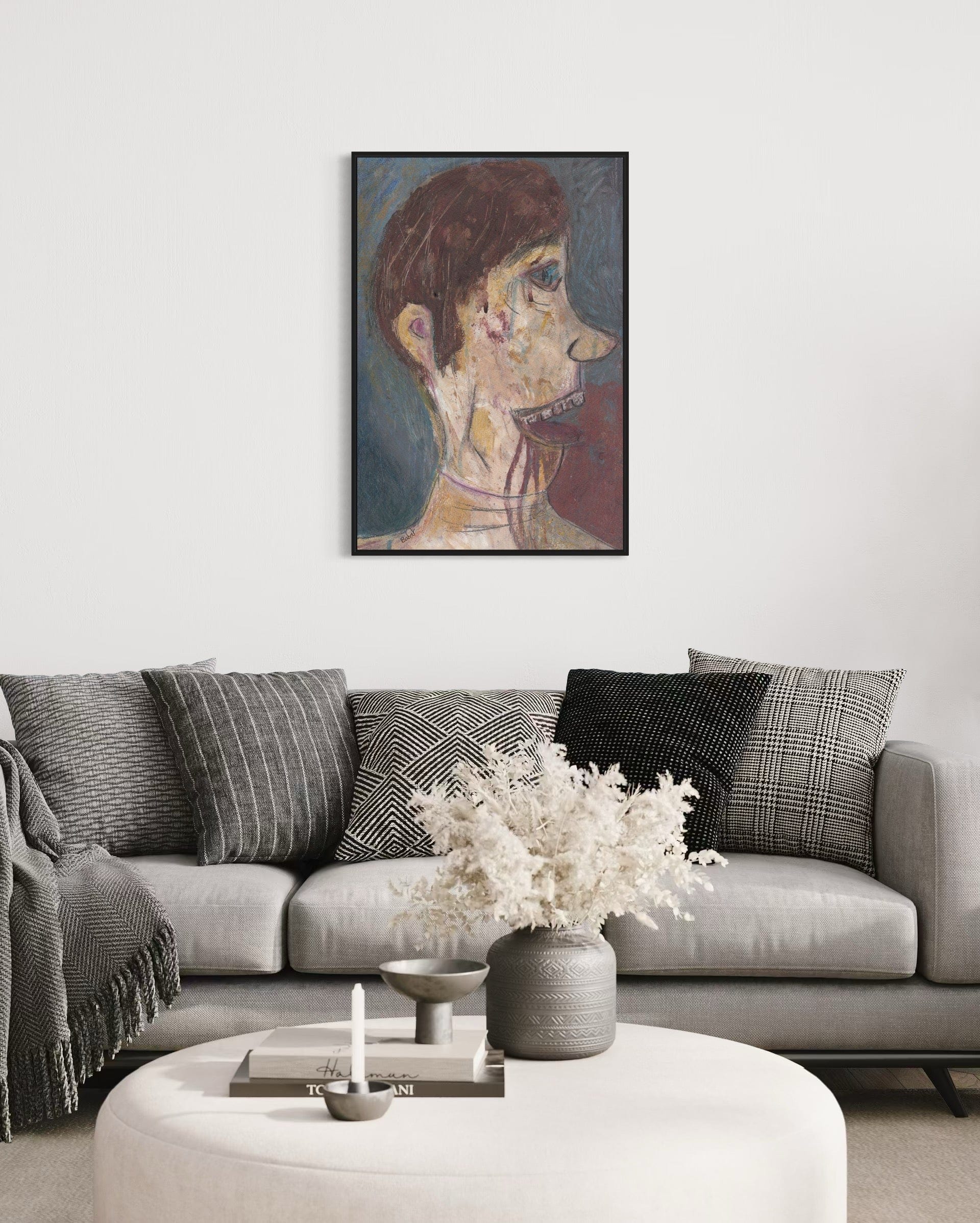 Living room with a gray sofa, decorative pillows, a vase with flowers, and a framed painting on the wall.