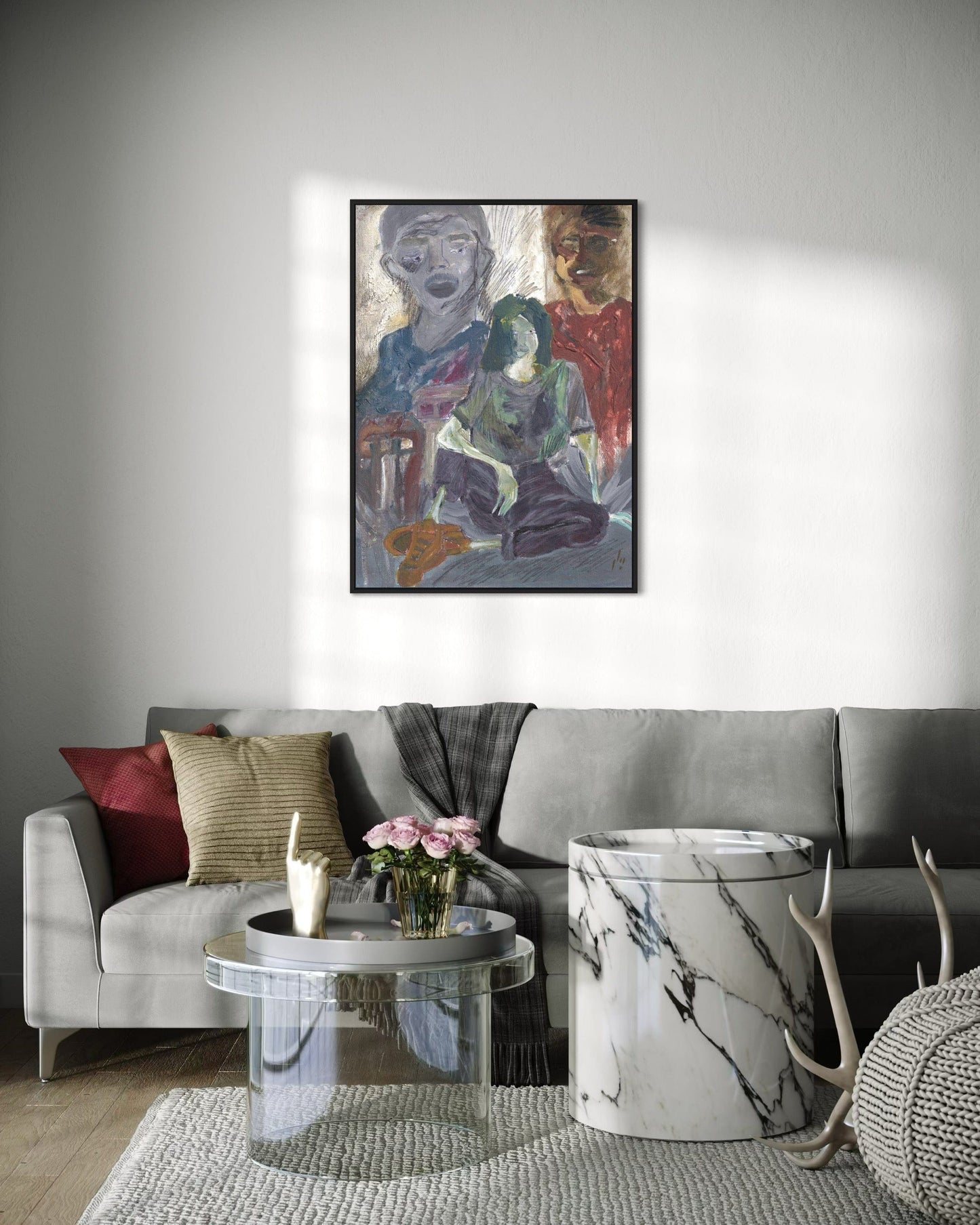 Living room with a gray sofa, coffee table, and decorative items, featuring a framed painting on the wall.