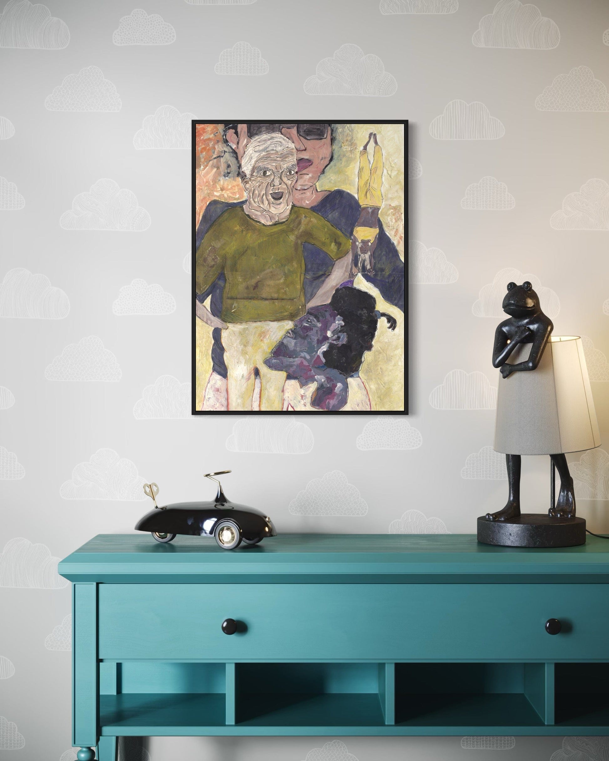 Framed artwork on a wall above a teal console table with decorative items.
