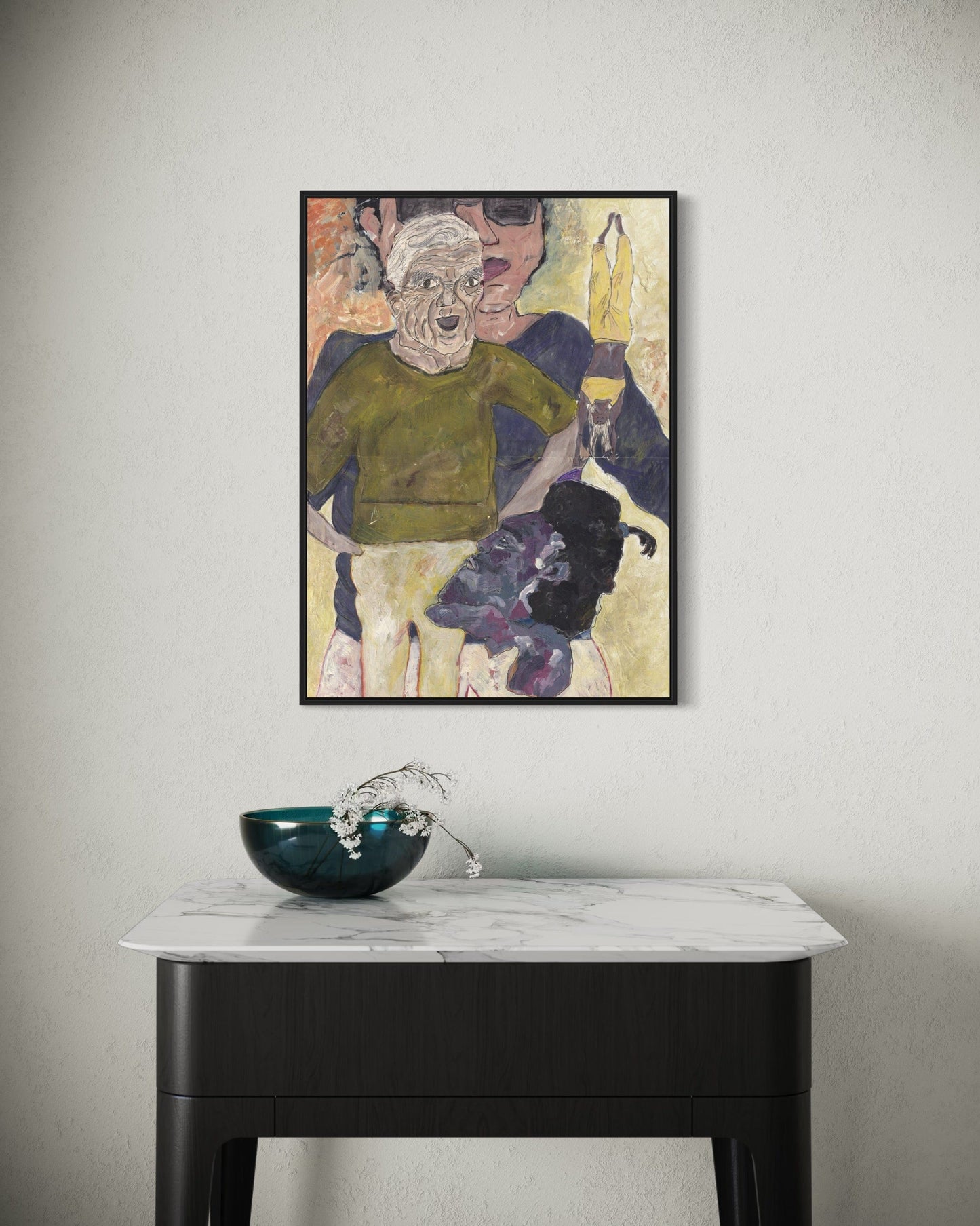 Framed artwork on a wall above a marble table with a decorative bowl.