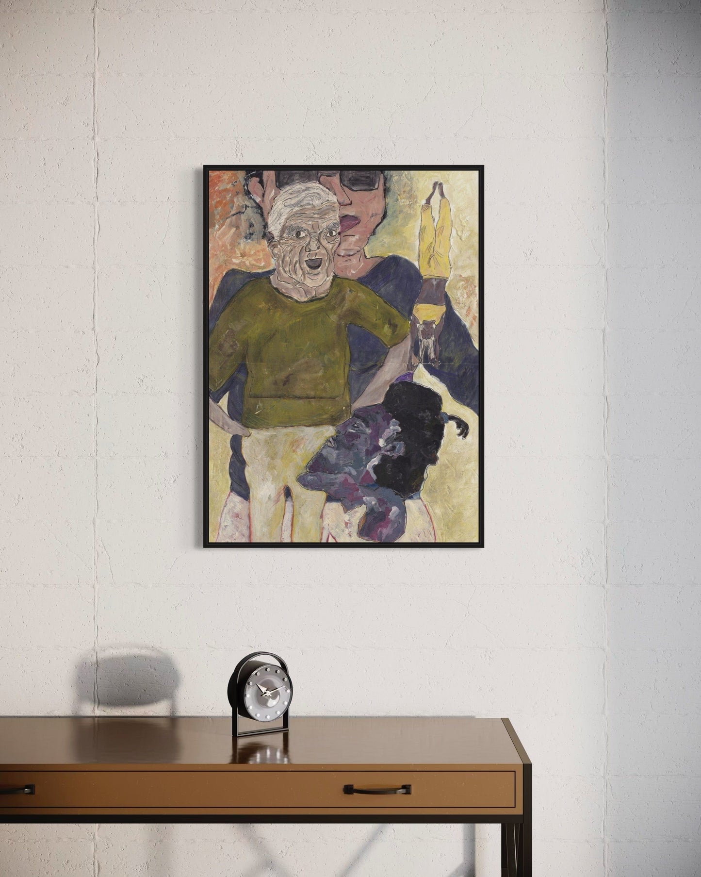 Framed artwork on a wall above a wooden desk with a clock.