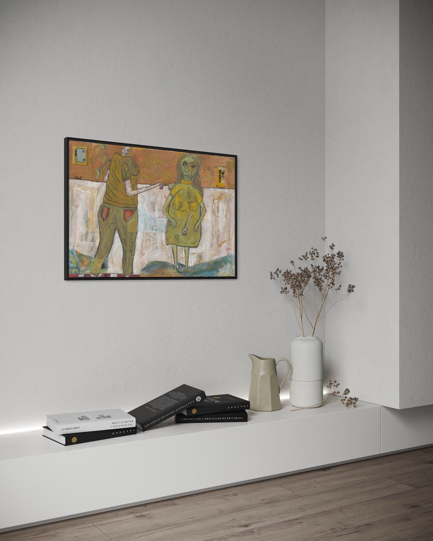 Framed abstract artwork on a wall above a shelf with decorative items.