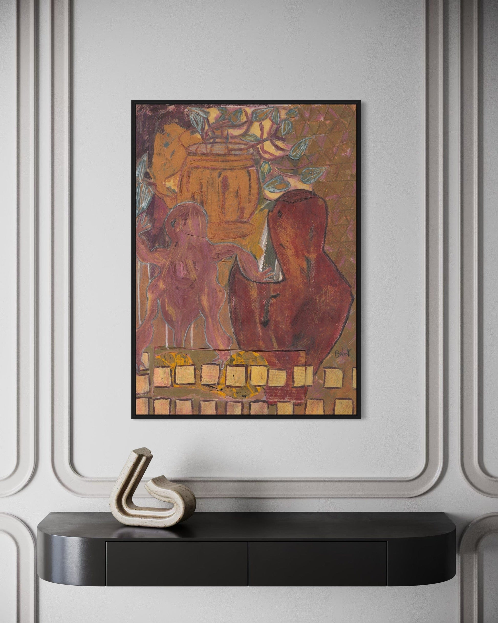 Framed artwork on a wall above a black console table with a decorative item.