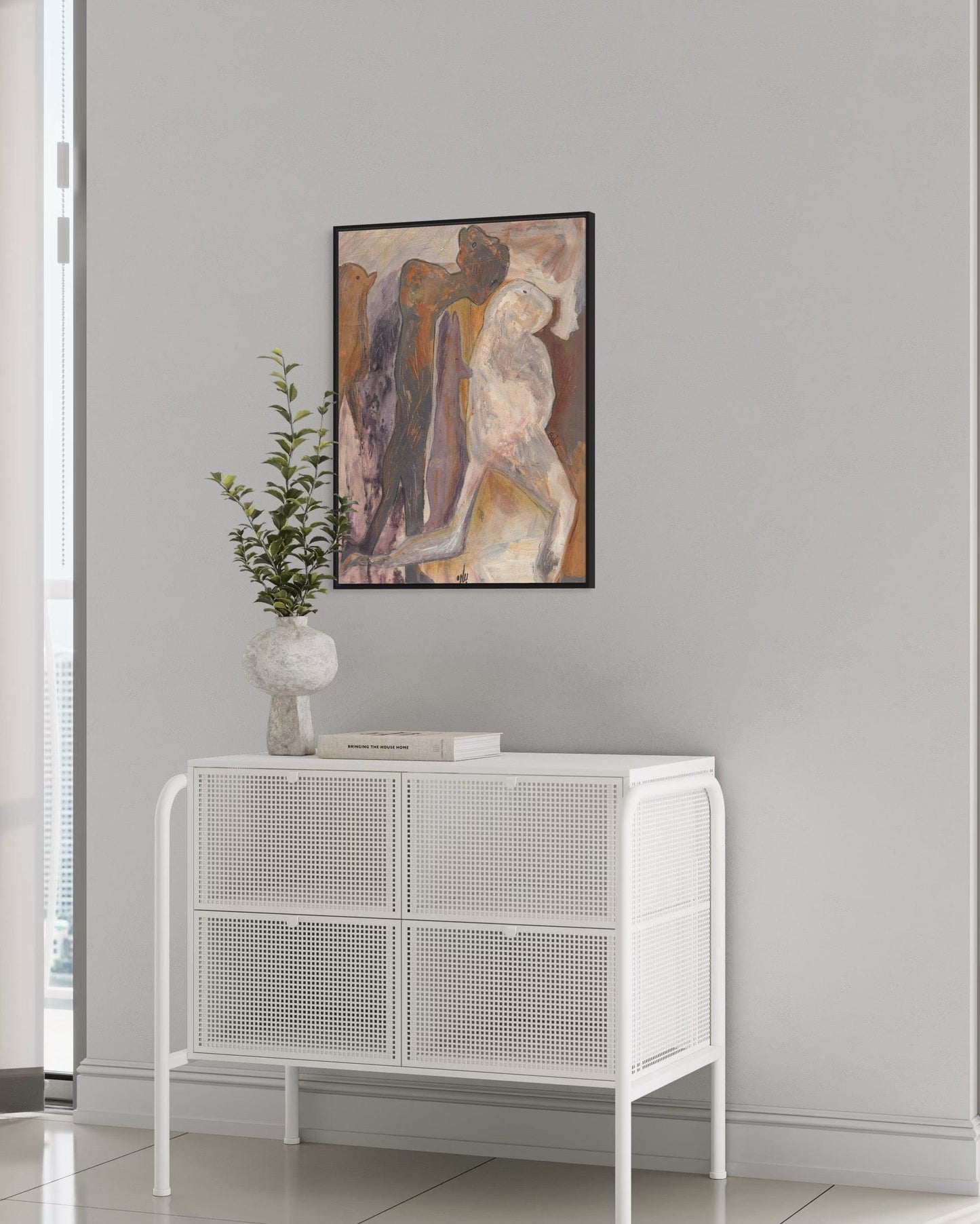 White cabinet with decorative items against a gray wall with a framed abstract painting.