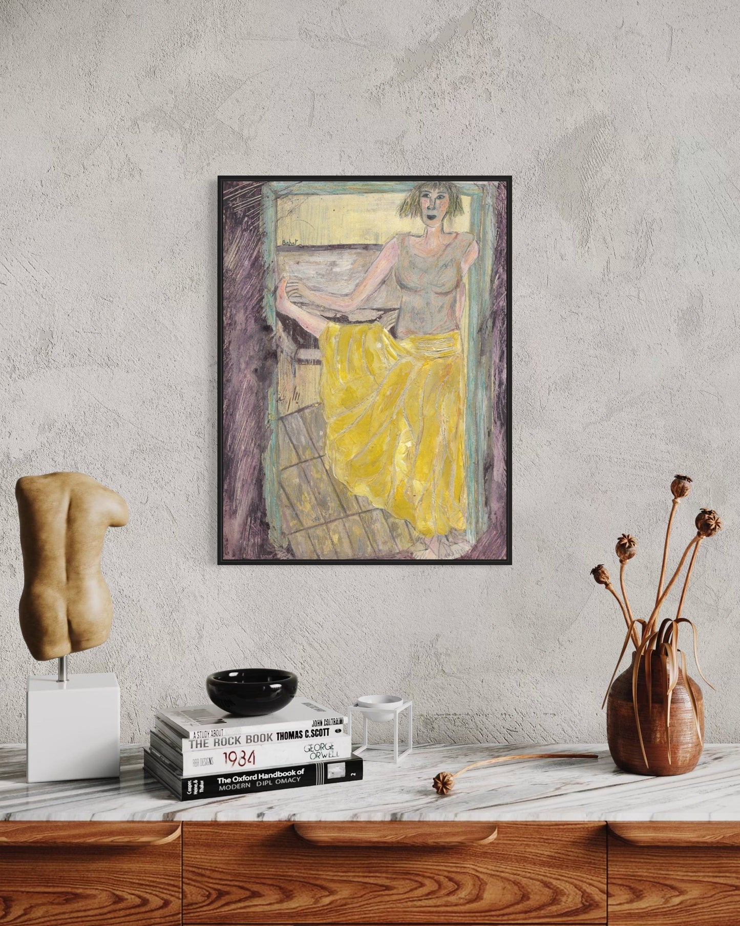 Framed artwork of a woman in a yellow dress on a wall above a wooden shelf with decor items.