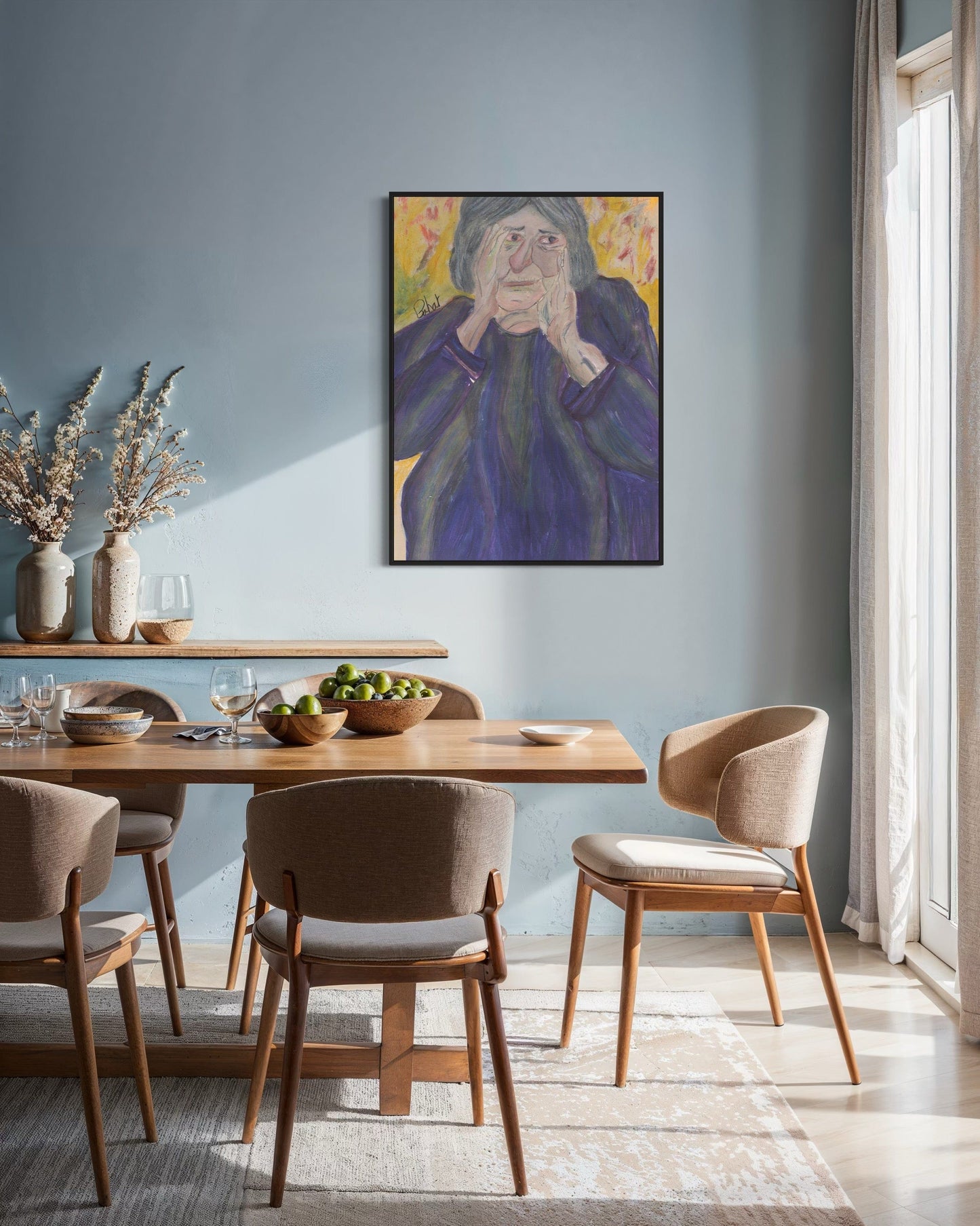 Dining room with wooden table and chairs, framed artwork on the wall, and natural light.
