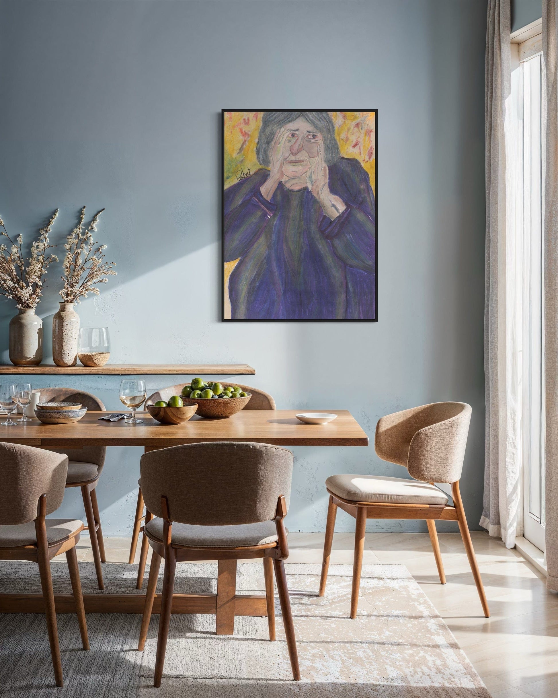 Dining room with wooden table and chairs, framed artwork on the wall, and natural light.