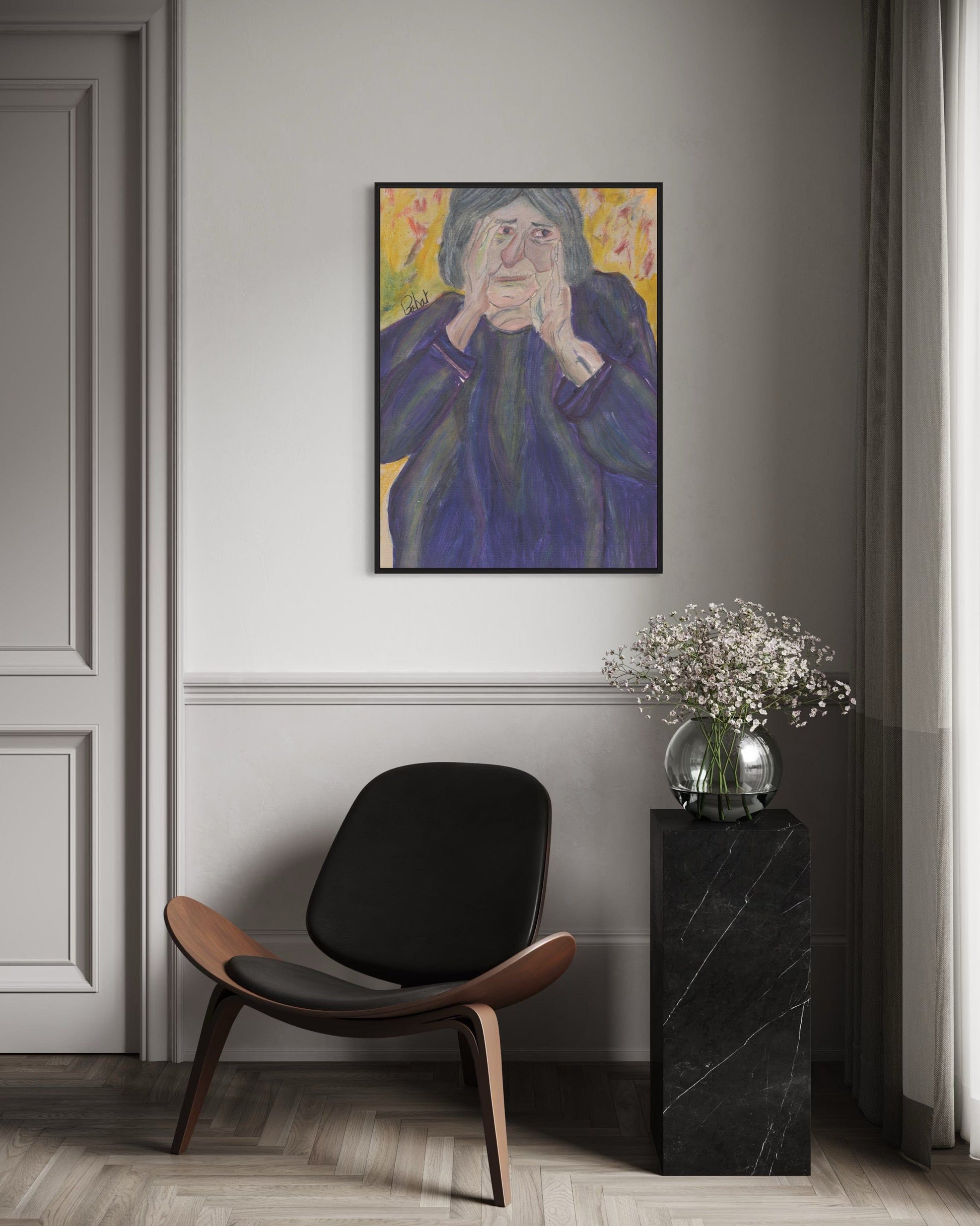 Modern interior with a black chair, side table, and framed artwork on a gray wall.