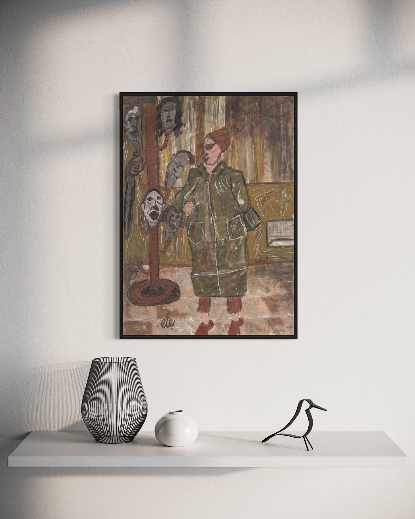 Framed artwork on a wall above a white shelf with decorative items.