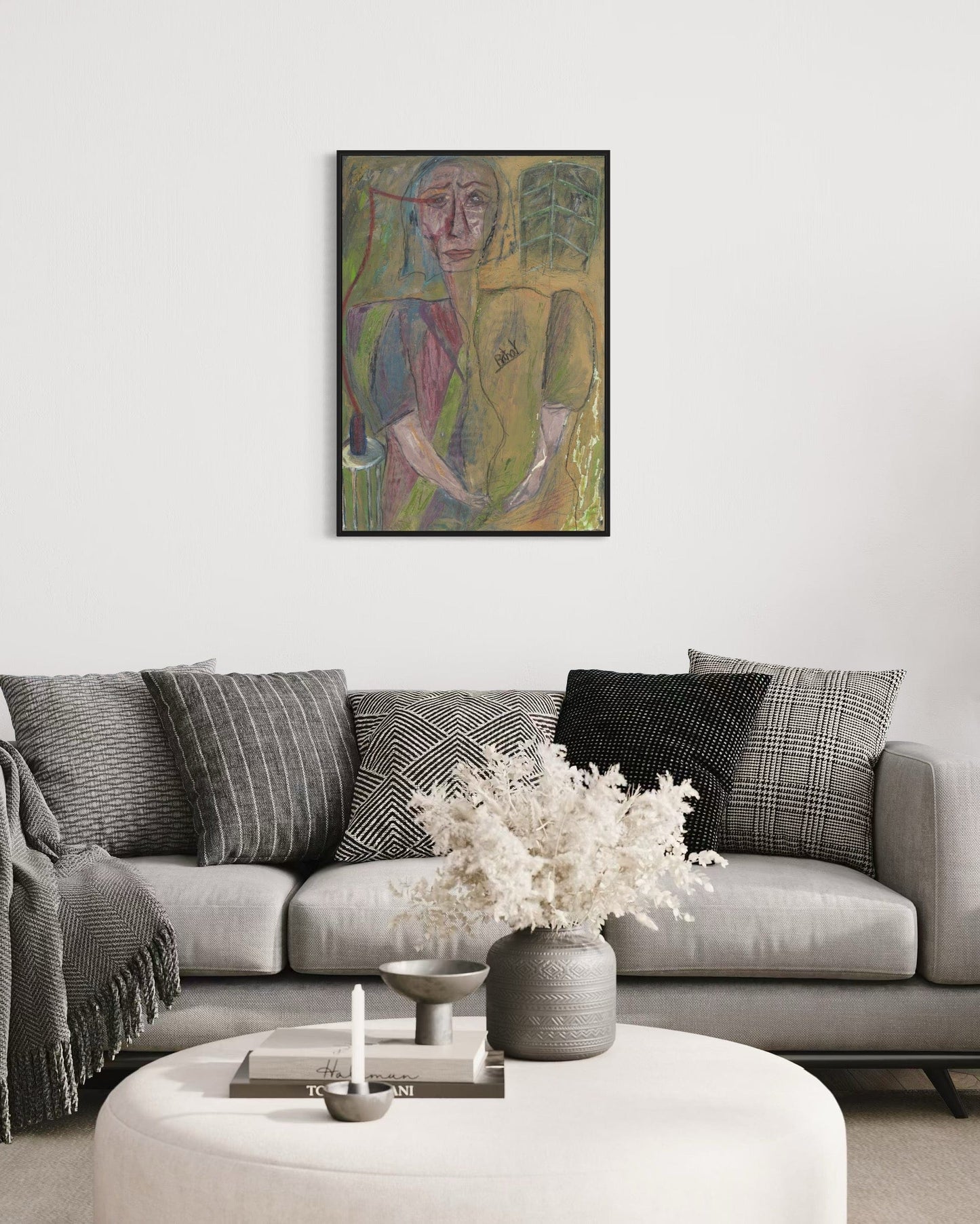 Living room with a gray sofa, decorative pillows, a vase with flowers, and a colorful abstract painting on the wall.