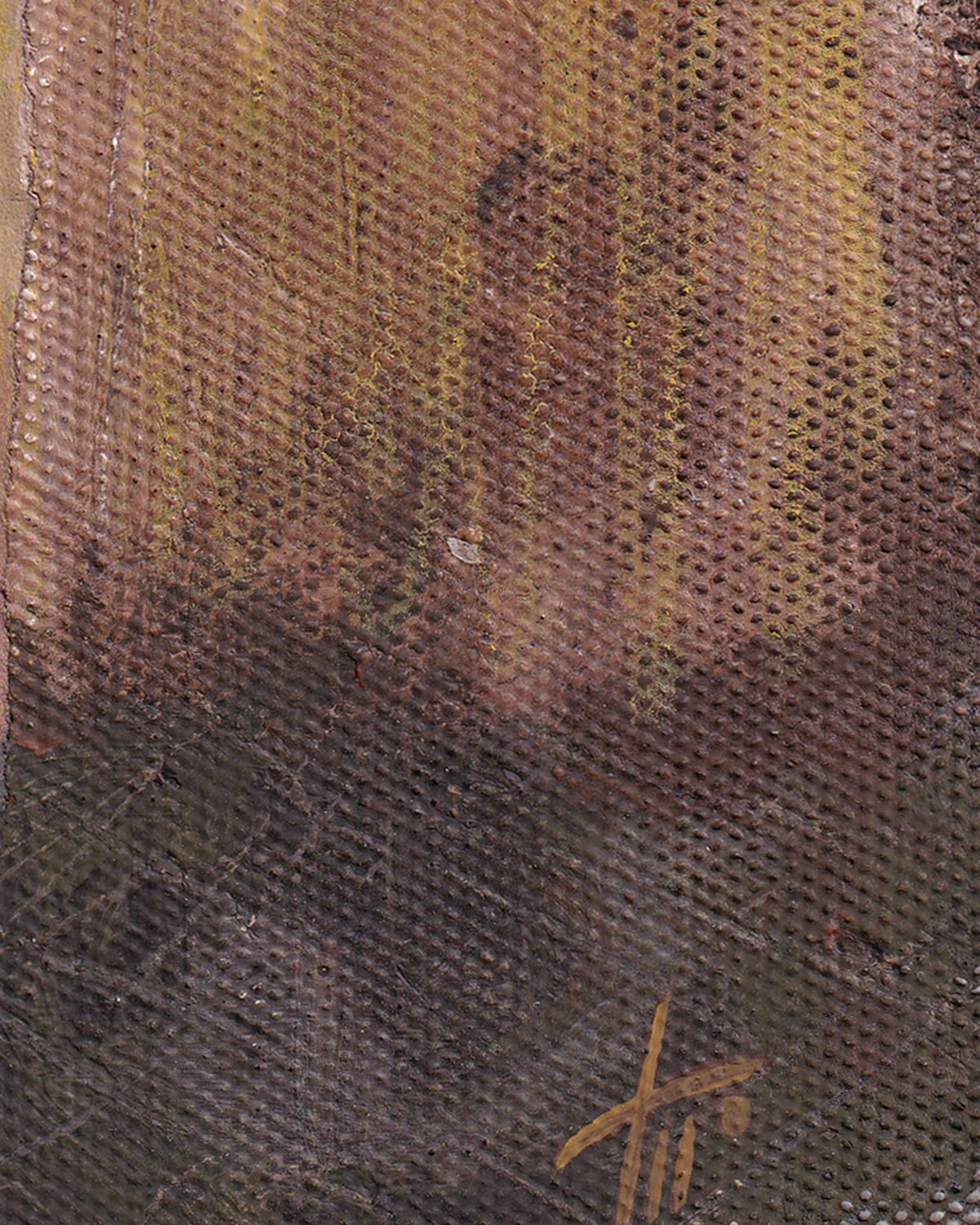 Close-up of textured fabric with a signature at the bottom right corner