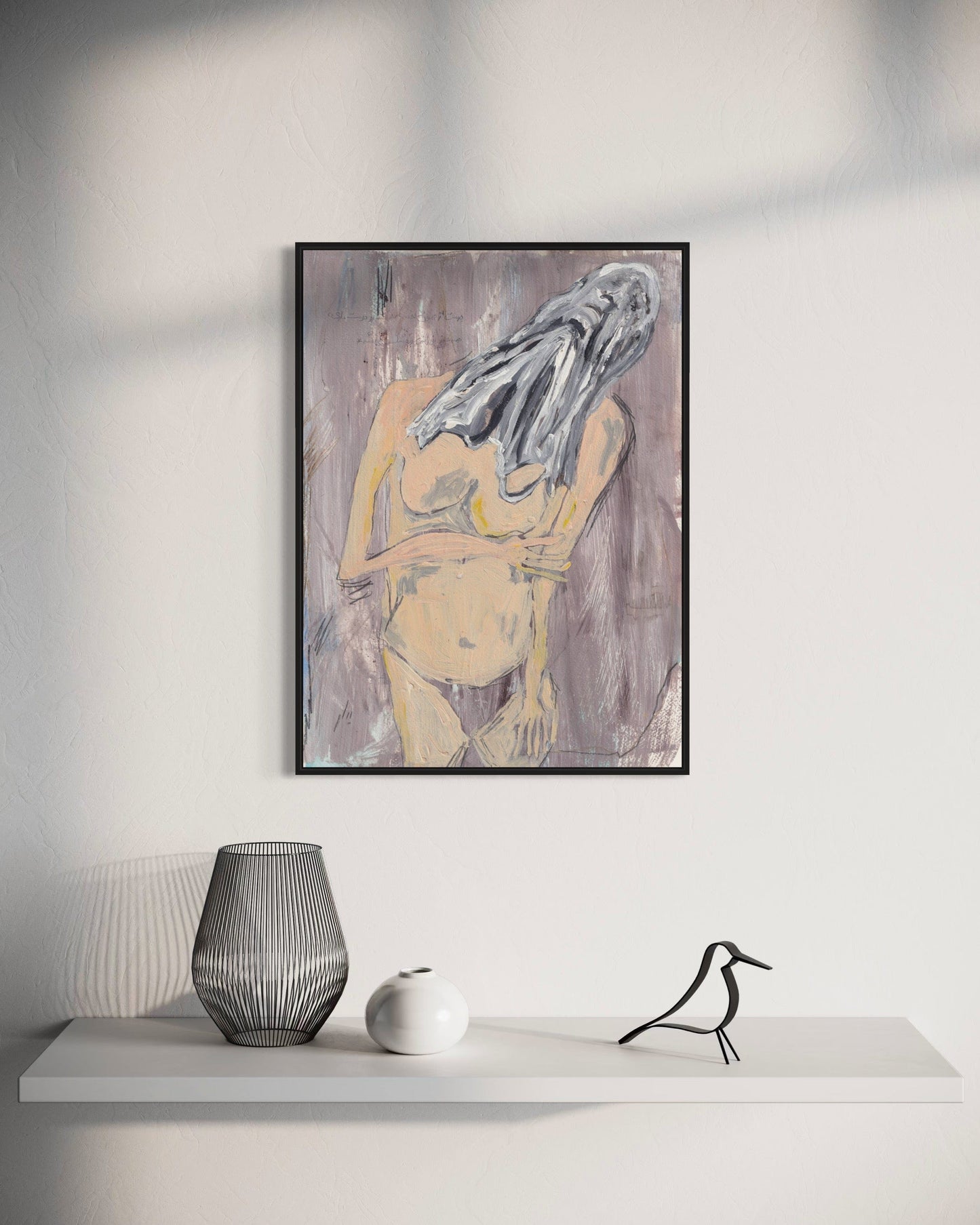 Framed abstract art piece on a wall above a white shelf with decorative items.