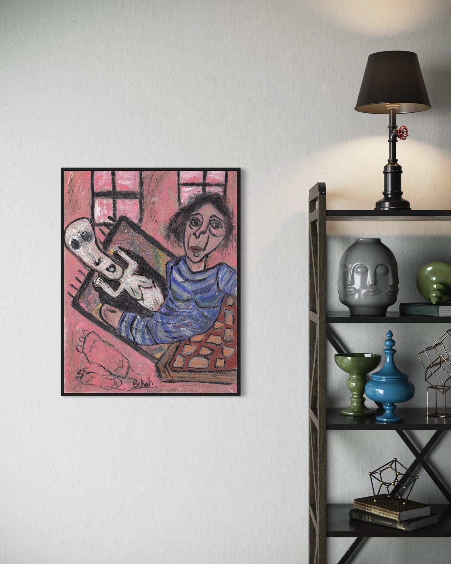 Framed artwork of a person holding a cat on a pink background, displayed on a wall next to a shelf with decorative items.