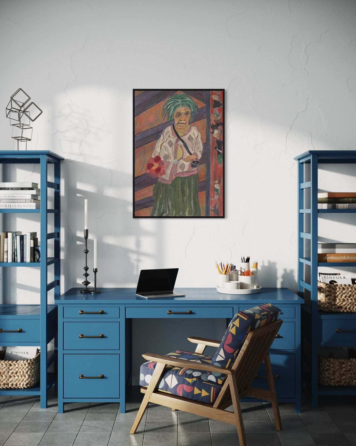 Home office with blue desk, chair, and bookshelves, featuring a colorful painting on the wall.