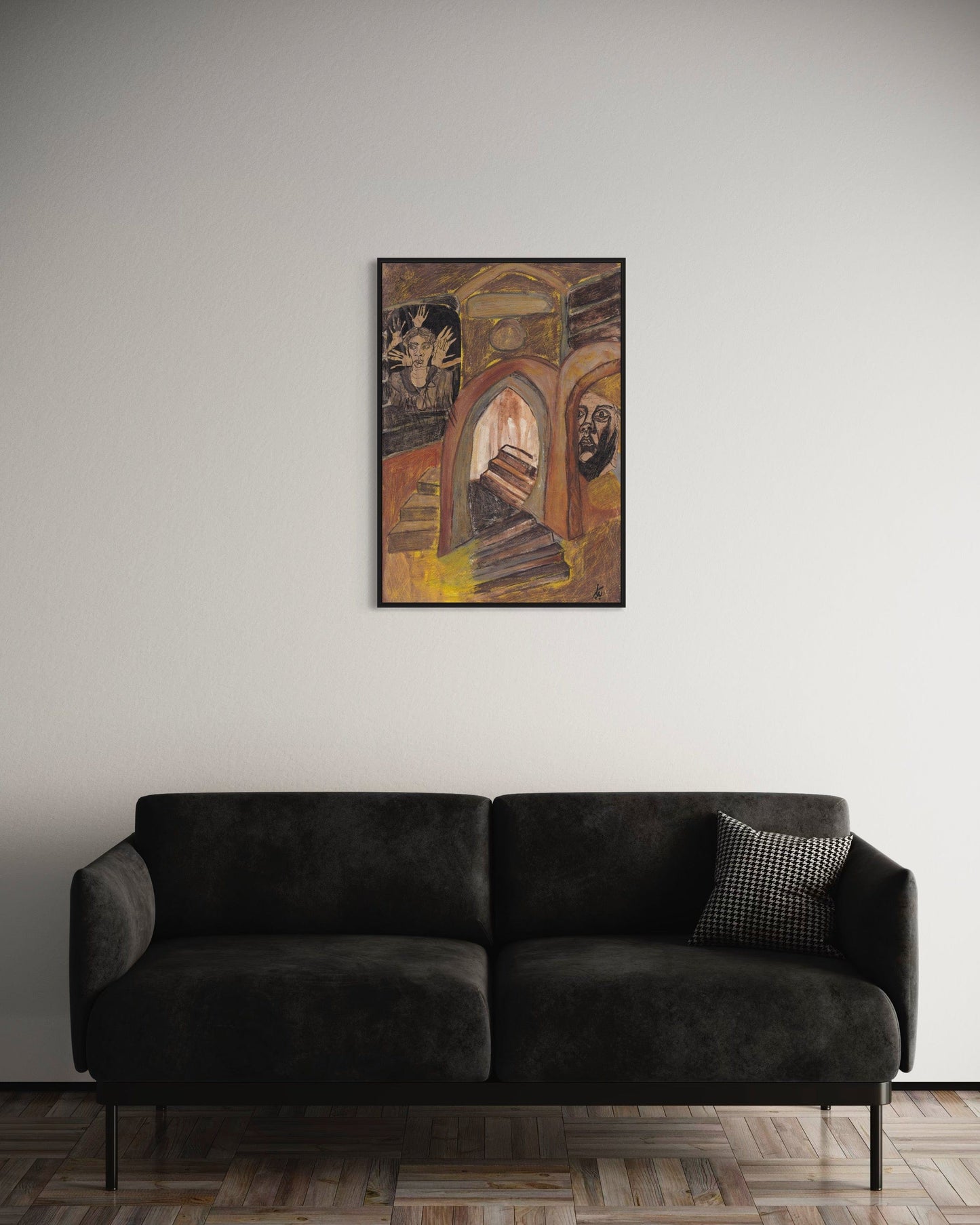 Dark gray sofa with a decorative pillow against a plain wall with a framed painting.